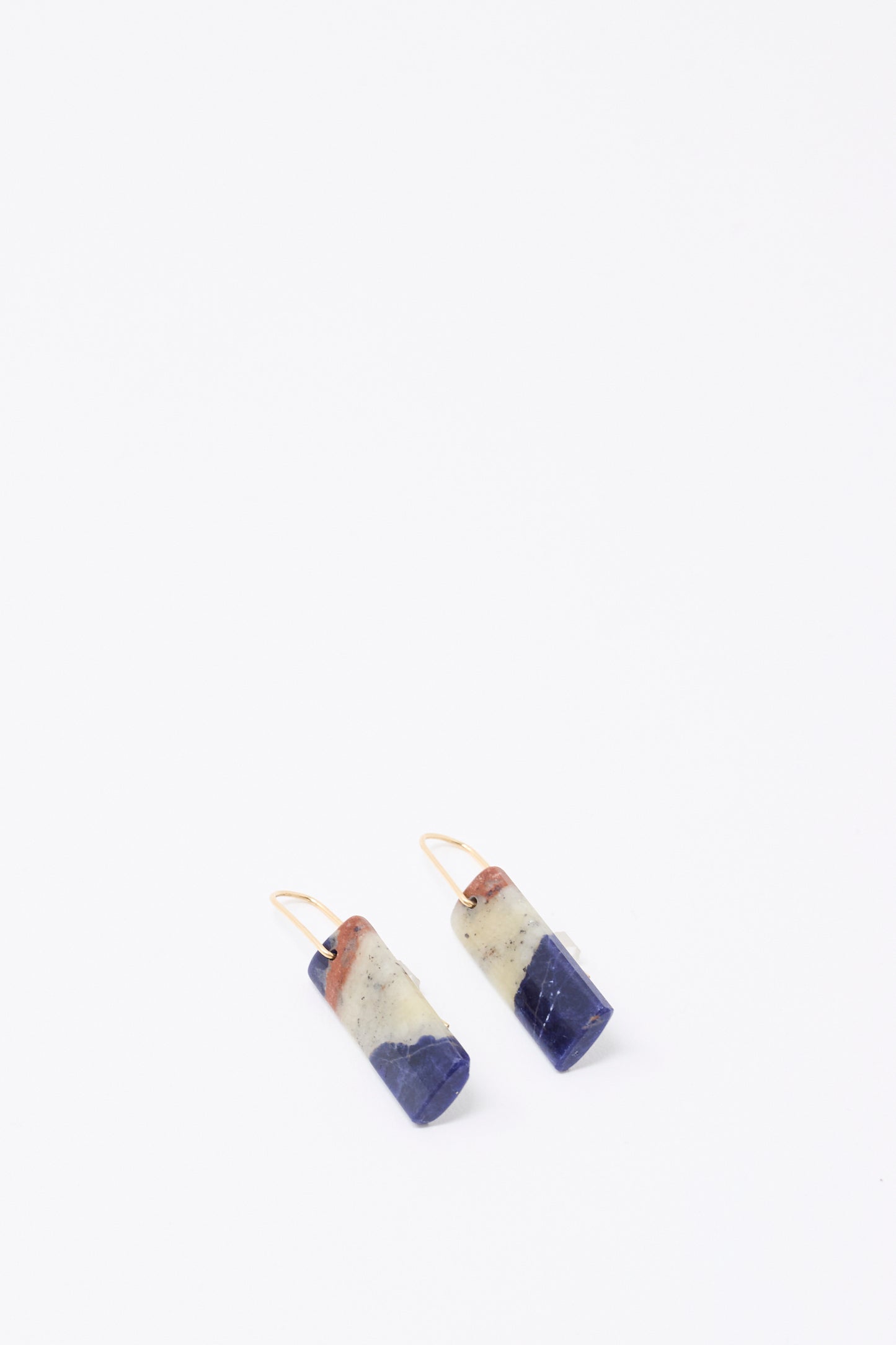 Mary MacGill Stone Drop Earrings in Sodalite feature handmade rectangular bands of blue, cream, and brown Sodalite stone with gold hooks, shown against a plain white background.