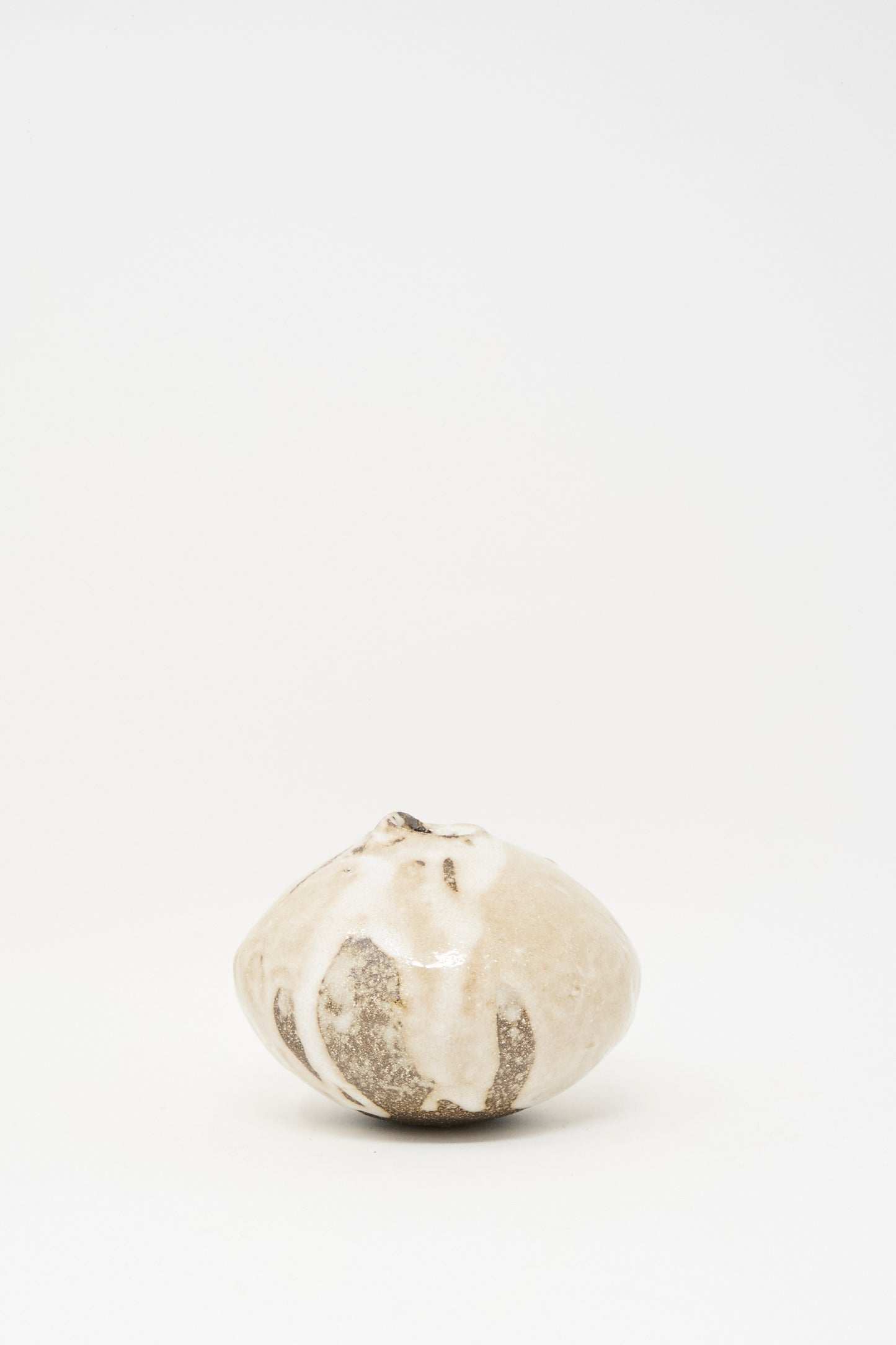 The Glazed Stoneware Mini Moon Bud Vase by MONDAYS features a round, multicolor textured surface in light beige and brown, and is displayed centered on a plain white background.