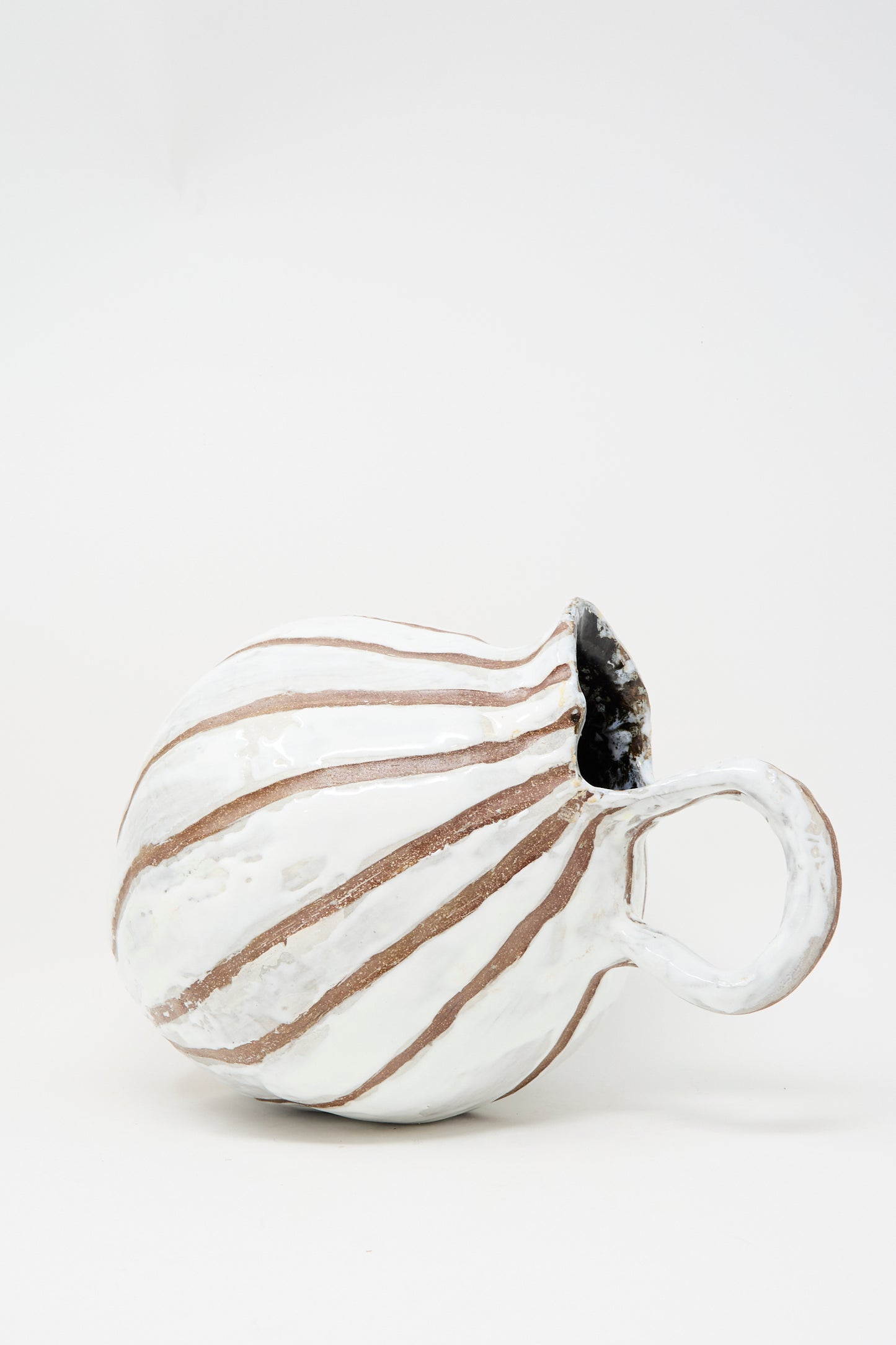 The MONDAYS Coil-built Glazed Stoneware Striped Pitcher Vase features a round body with white glazed and brown vertical stripes, displayed on its side against a plain white background. Available for in-store pickup.