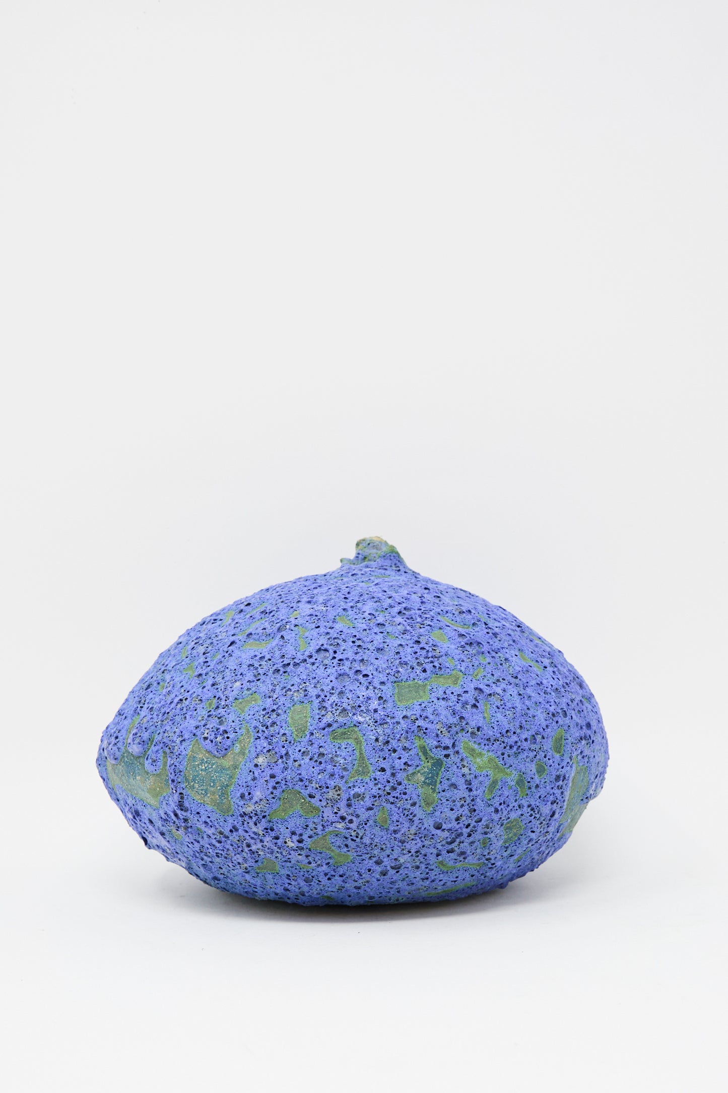 The MONDAYS Glazed Stoneware Moon Vase in Blue, sits on a plain white background—its handmade look and blue glaze lending it distinctive character.