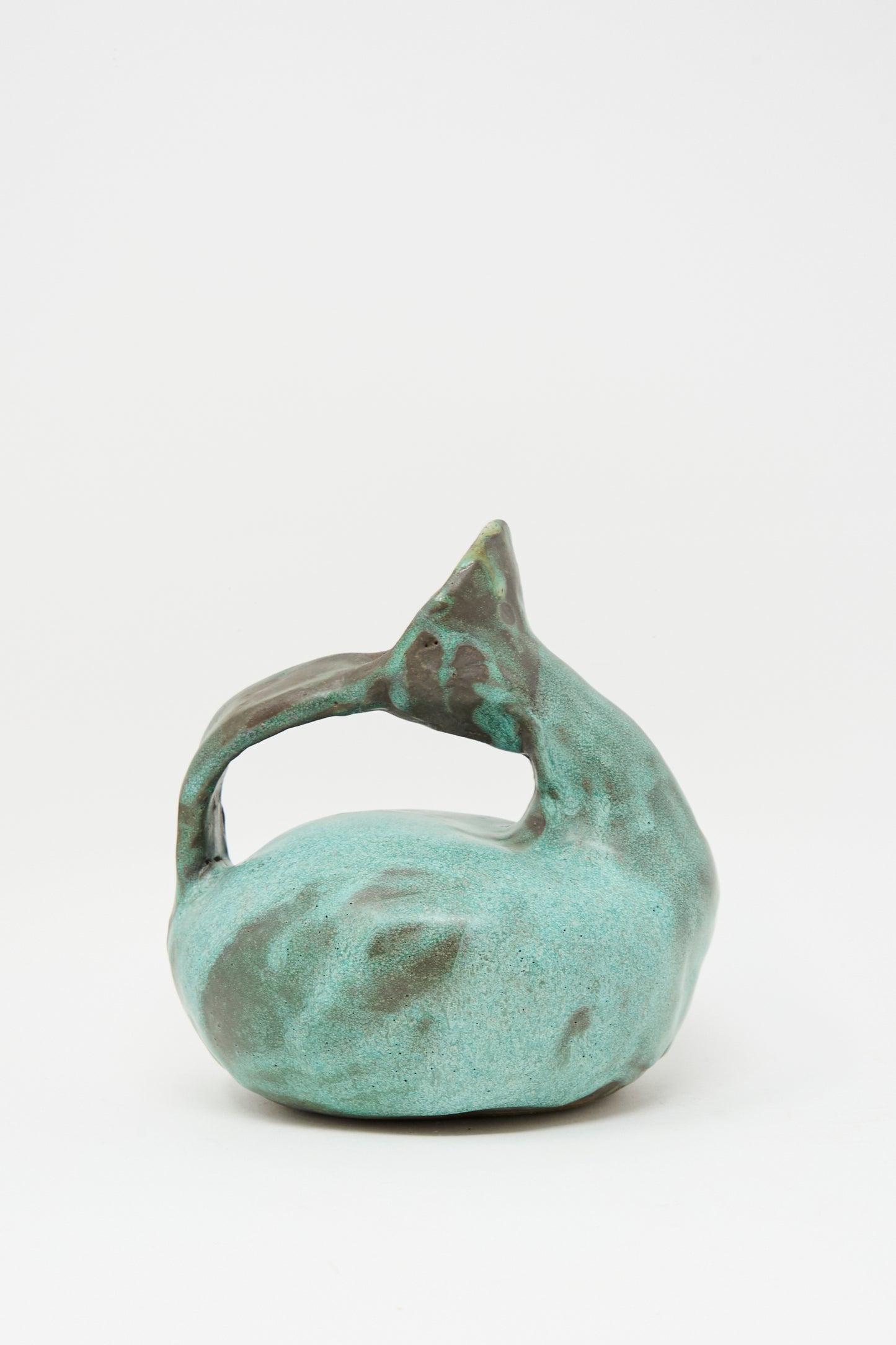 The MONDAYS Glazed Stoneware Pitcher Vase in Green features a hand-built, curved design with an arching handle and a green glazed finish, evoking the look of an abstract ceramic sculpture.