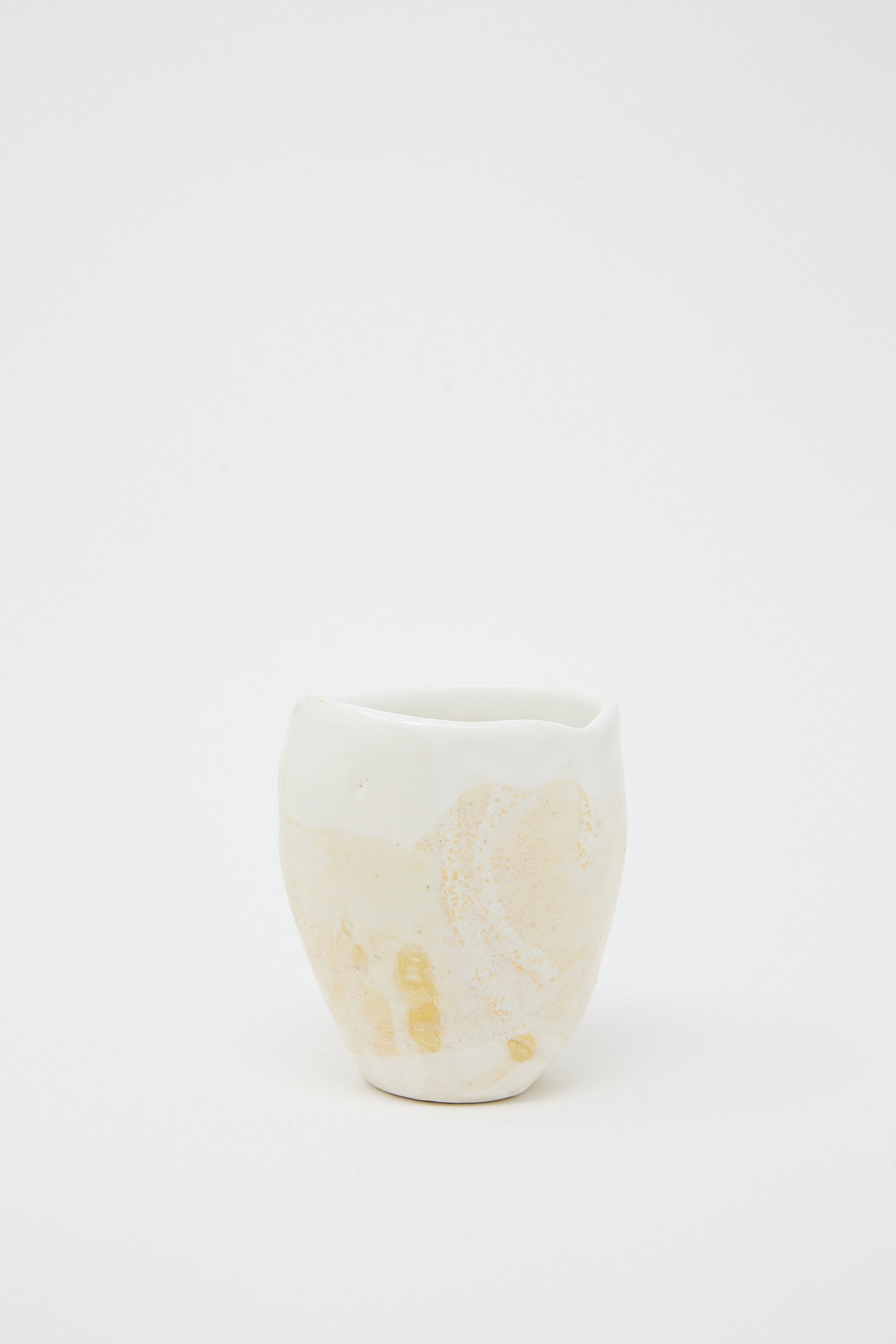 A MONDAYS white hand-built Porcelain Tumbler in Beige and White with a textured glaze on a white background.