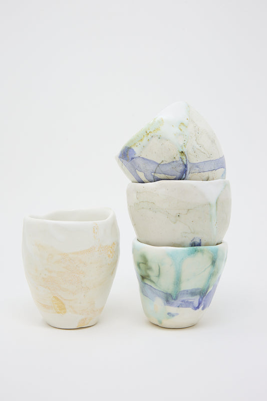 Four MONDAYS Porcelain Tumblers in Beige and White, three stacked on top of each other and one next to the stack.