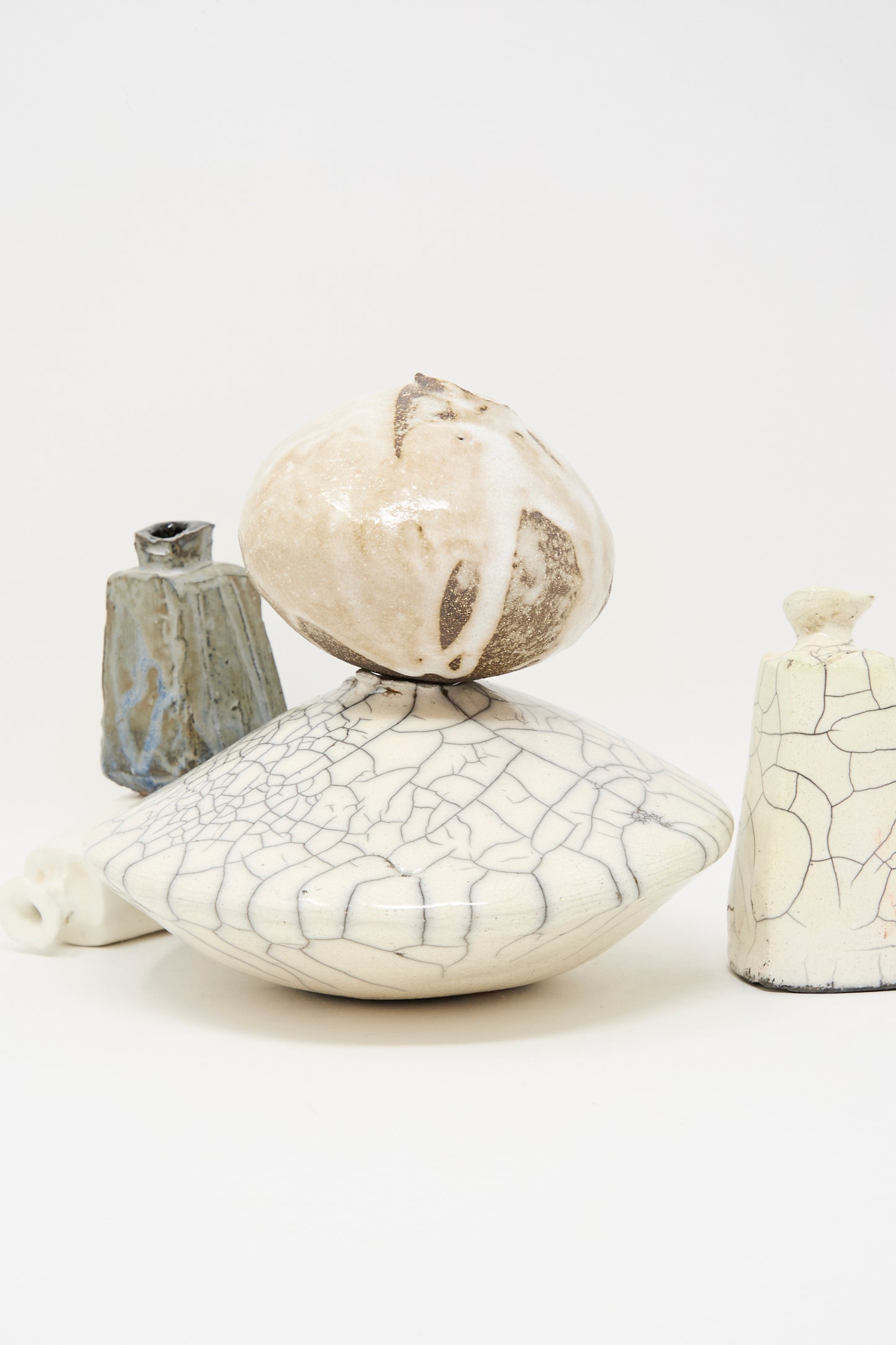 The MONDAYS Raku Ikebana Vase Large, shown with two other ceramic vessels, features crackle glaze and organic shapes, arranged together against a white background.