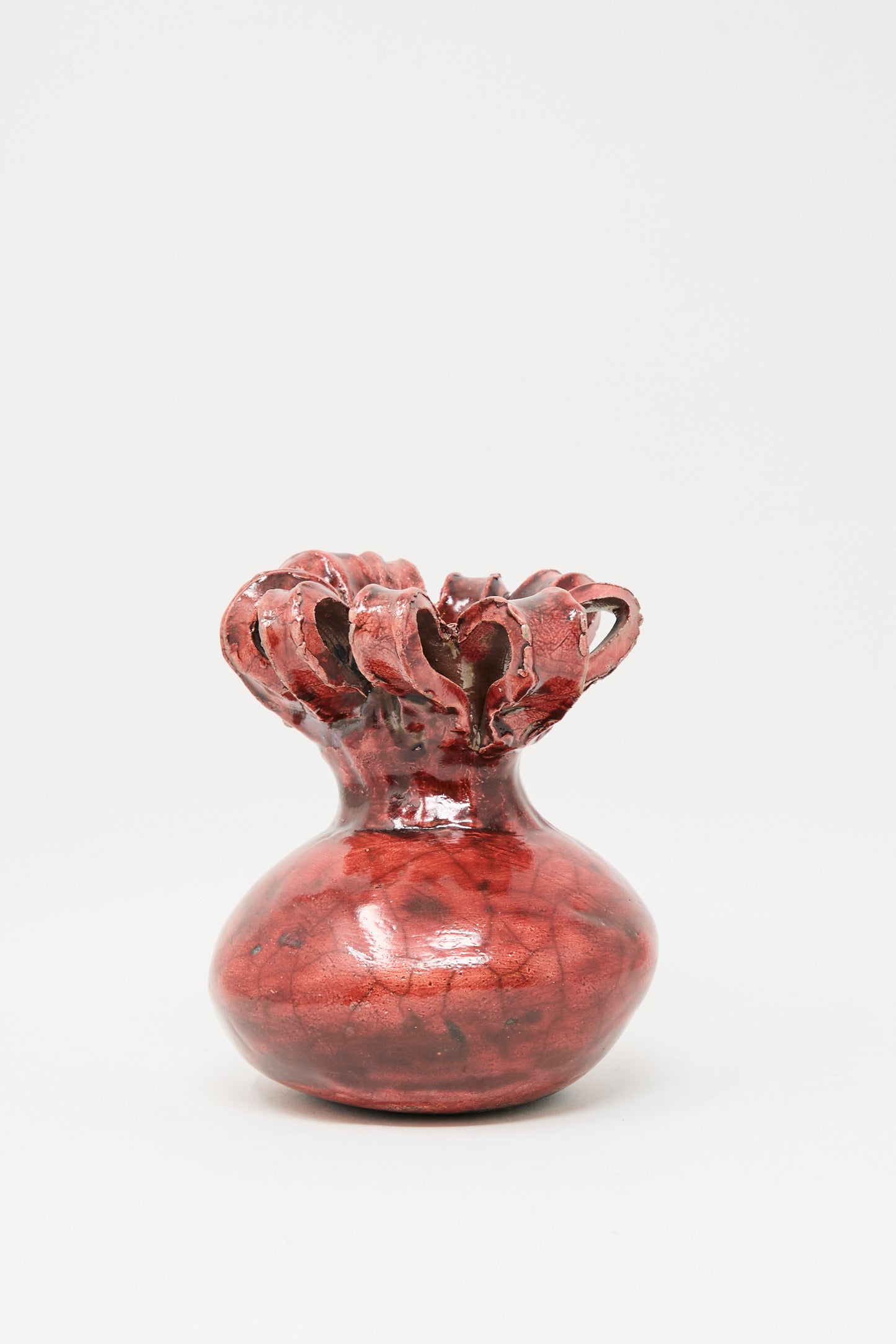 The MONDAYS Raku Ribbon Vase in Red, featuring a glossy finish, bulbous base, and sculpted open top, is showcased against a plain white background.