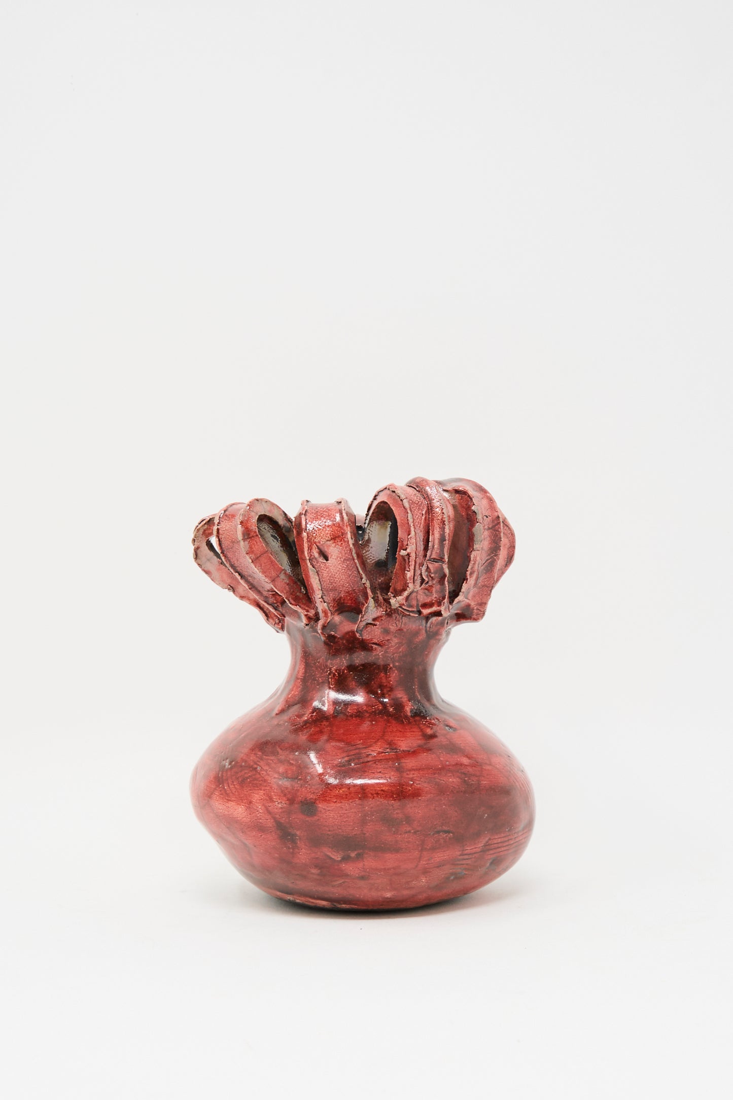 The Raku Ribbon Vase in Red by MONDAYS is a hand-built ceramic vase featuring a bulbous base and ruffled, textured rim, shown against a plain white background.