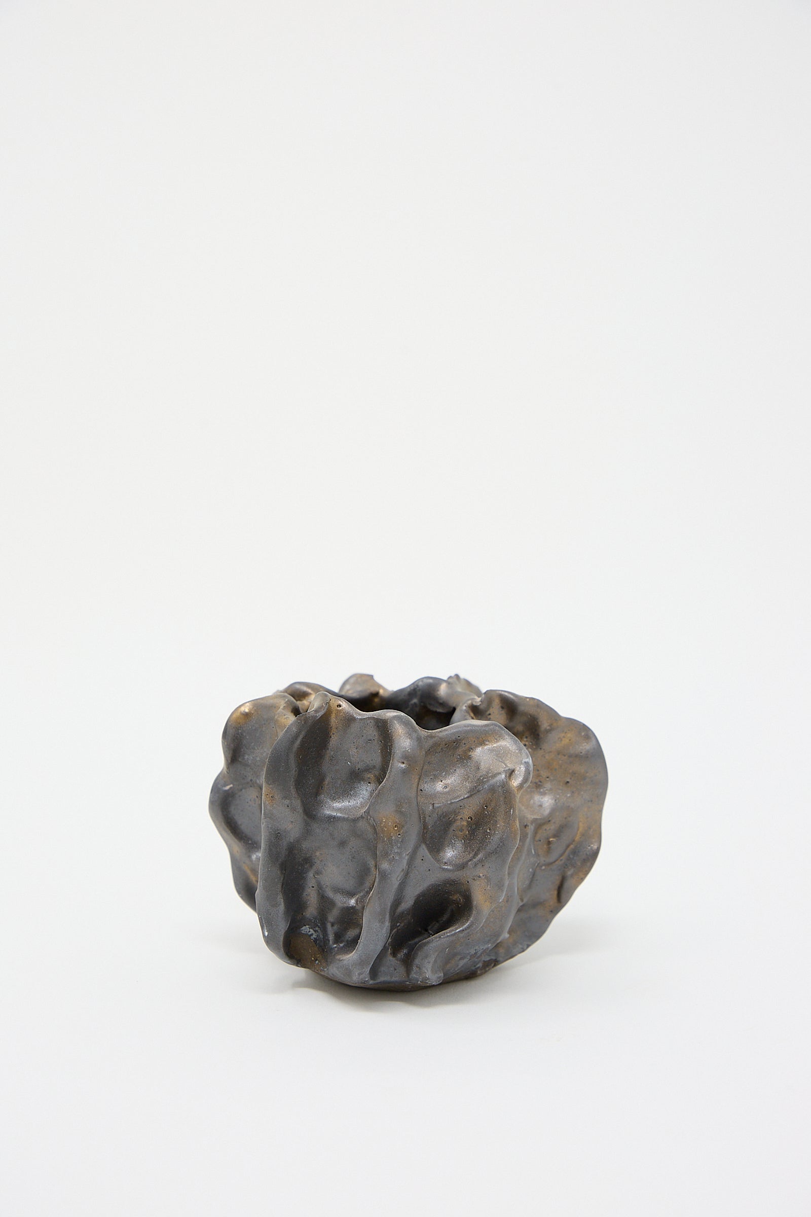 A handmade Urchin Vessel in Glazed Stoneware from MONDAYS in black and brown on a white surface.