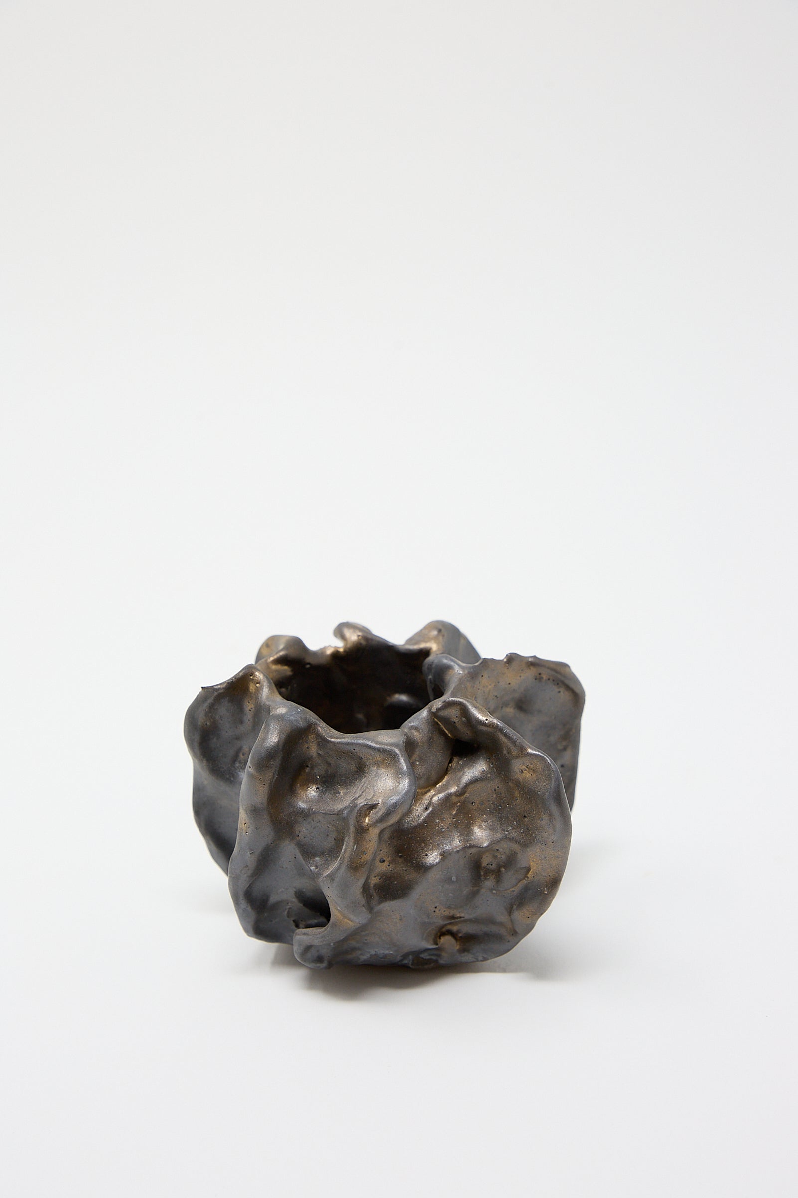 A small piece of Urchin Vessel in Glazed Stoneware by MONDAYS sitting on a white surface.