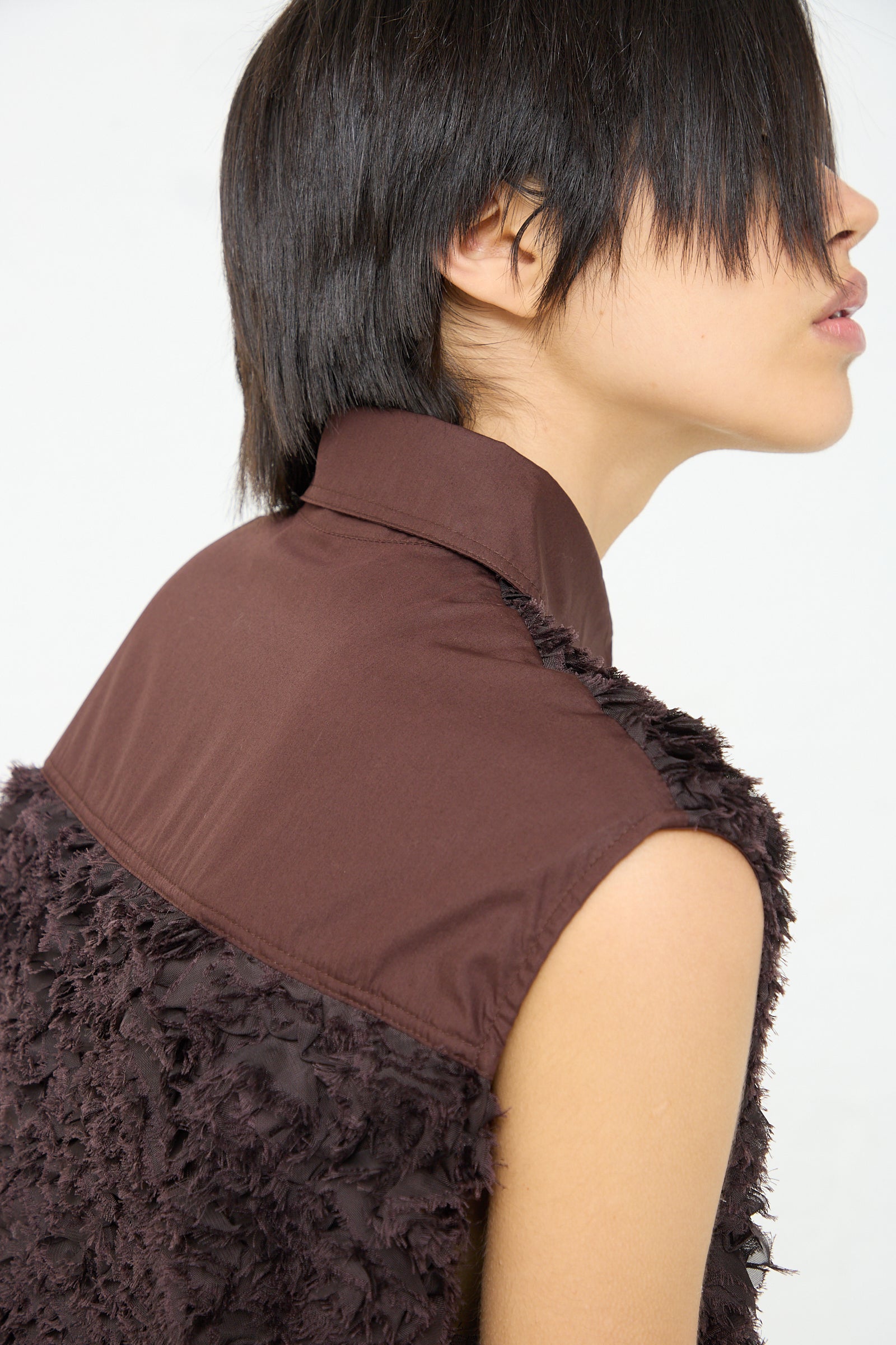 The back view of a woman wearing an intricately embroidered Embroidered Tulle Beagle Shirt Dress in Dark Brown by Niccolò Pasqualetti. Side view. Up close.