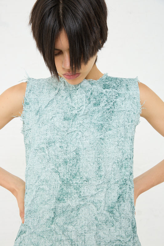 A woman in a Frayed Tarpaulin Carta Tank in Mint by Niccolò Pasqualetti with her hands on her hips.