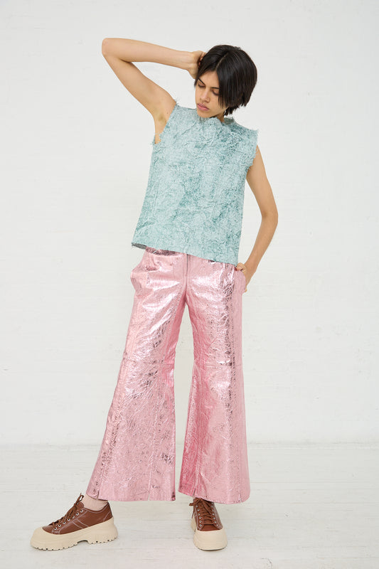 A woman wearing a Frayed Tarpaulin Carta Tank in Mint by Niccolò Pasqualetti and pink sequin pants.
