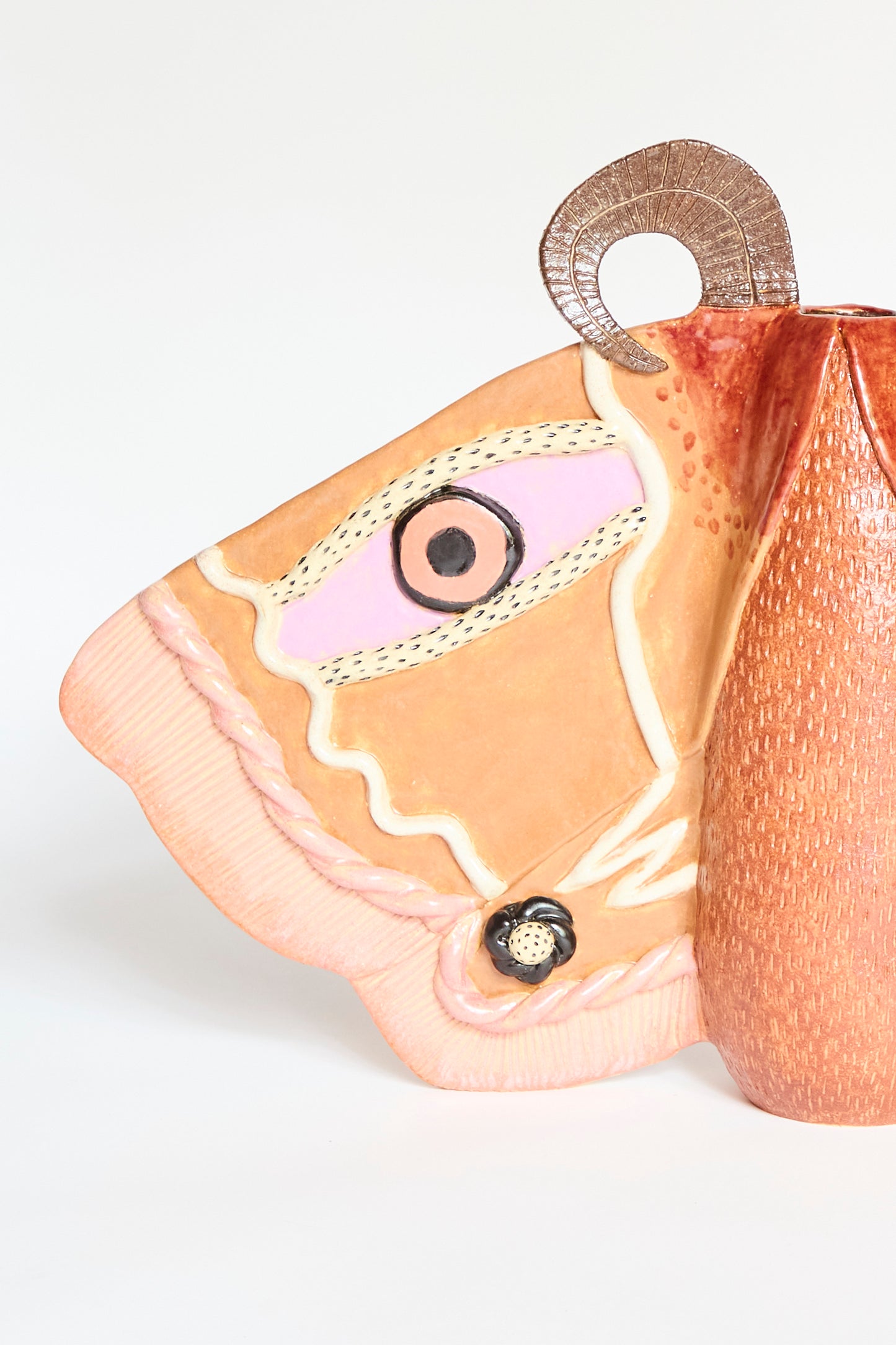 The Emperor Moth in Rust by Pearce Williams is a handmade stoneware sculpture resembling a moth's wing, with detailed patterns and textured surfaces in pink, brown, and cream tones.