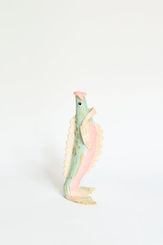 The Pearce Williams Fish Vase Large in Green is a handmade, stoneware vase with a fish shape and pastel green color, shown standing upright against a plain white background.