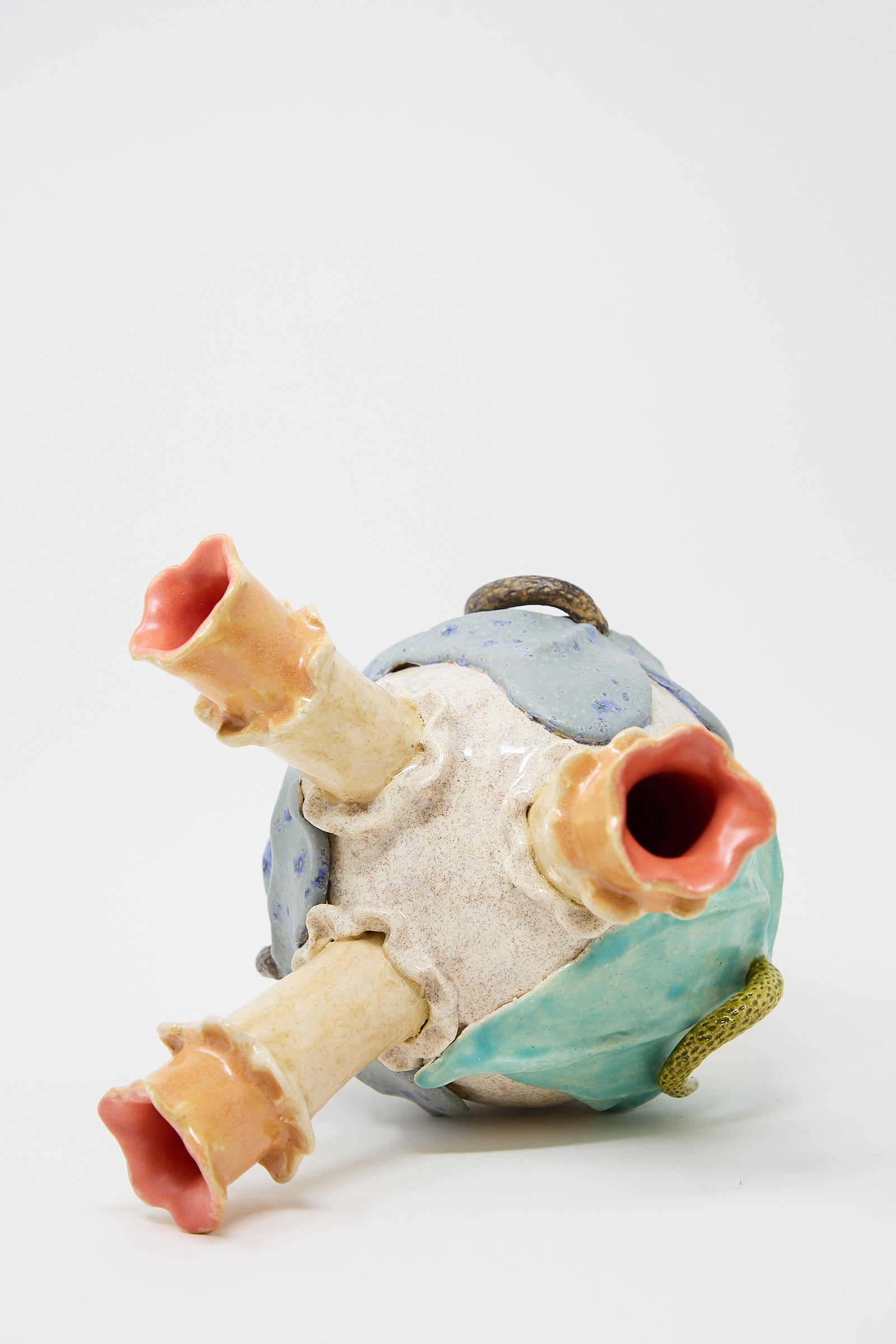 A colorful ceramic sculpture resembling a Floral Triple Vase by Pearce Williams, with blue and neutral tones, set against a white background. This piece is representative of New Orleans ceramics.