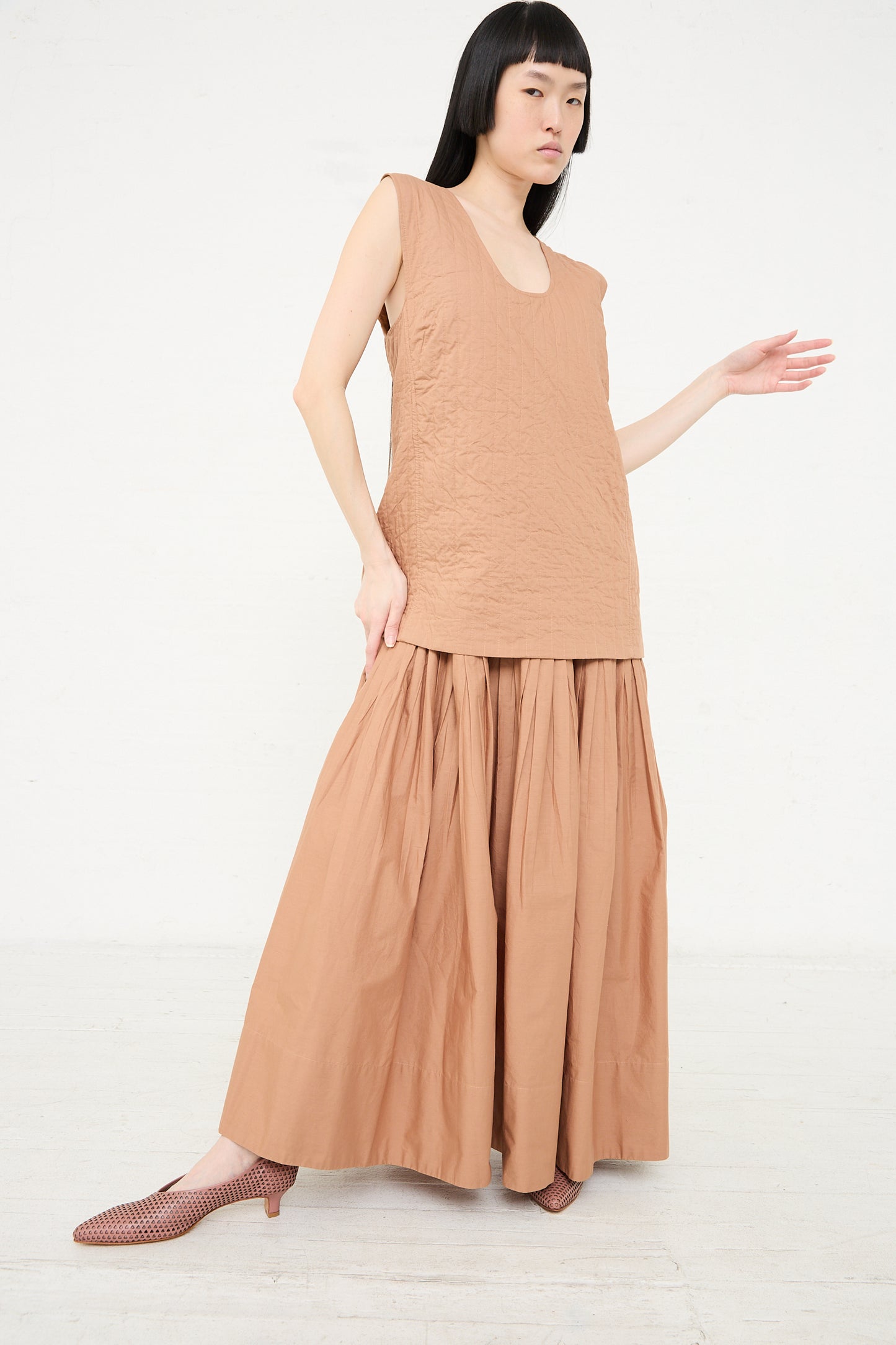 Woman in a sleeveless Rachel Comey Calin Dress in Camel posing on a white background.
