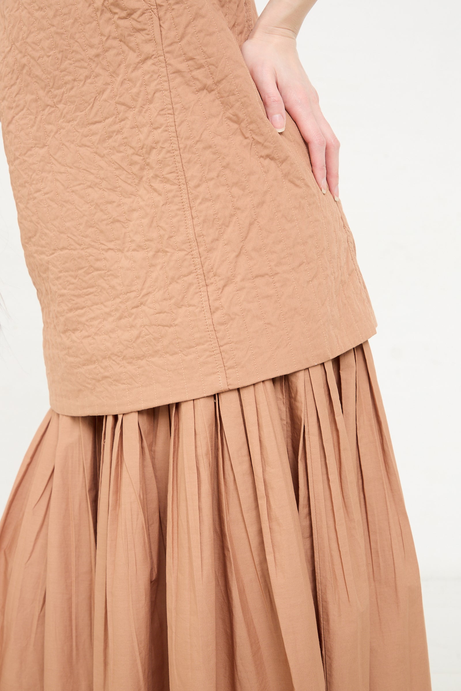 A close-up of a person modeling a Calin Dress in Camel by Rachel Comey.