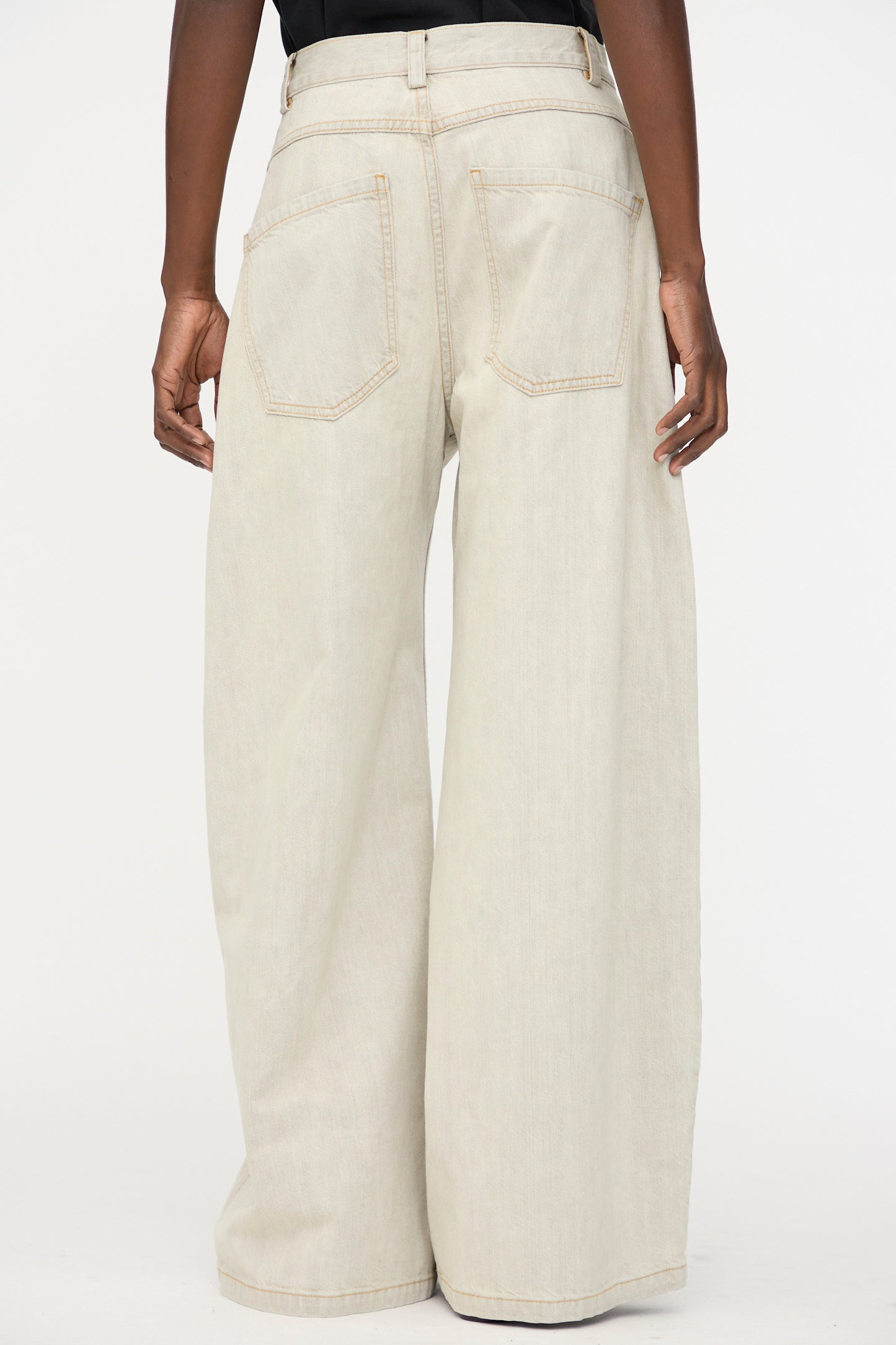 A person wears Rachel Comey's Dottir Pant in Khaki Wash, styled oversized and wide-leg, shown from the back with hands relaxed at their sides against a plain background.