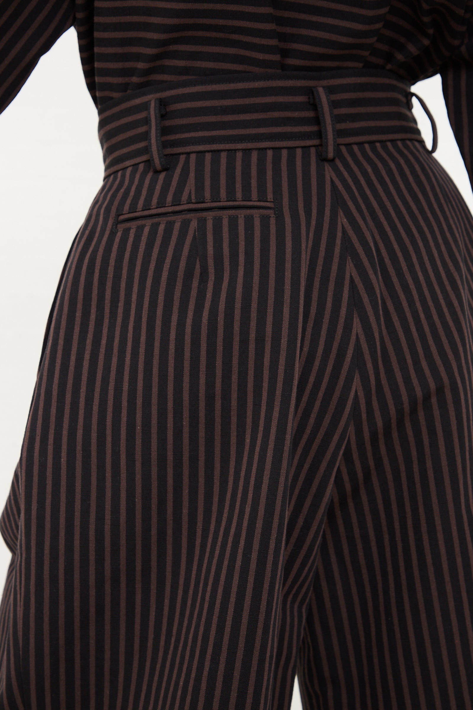 Close-up of a person wearing Rachel Comey's Melio Short in Black with a matching belt.