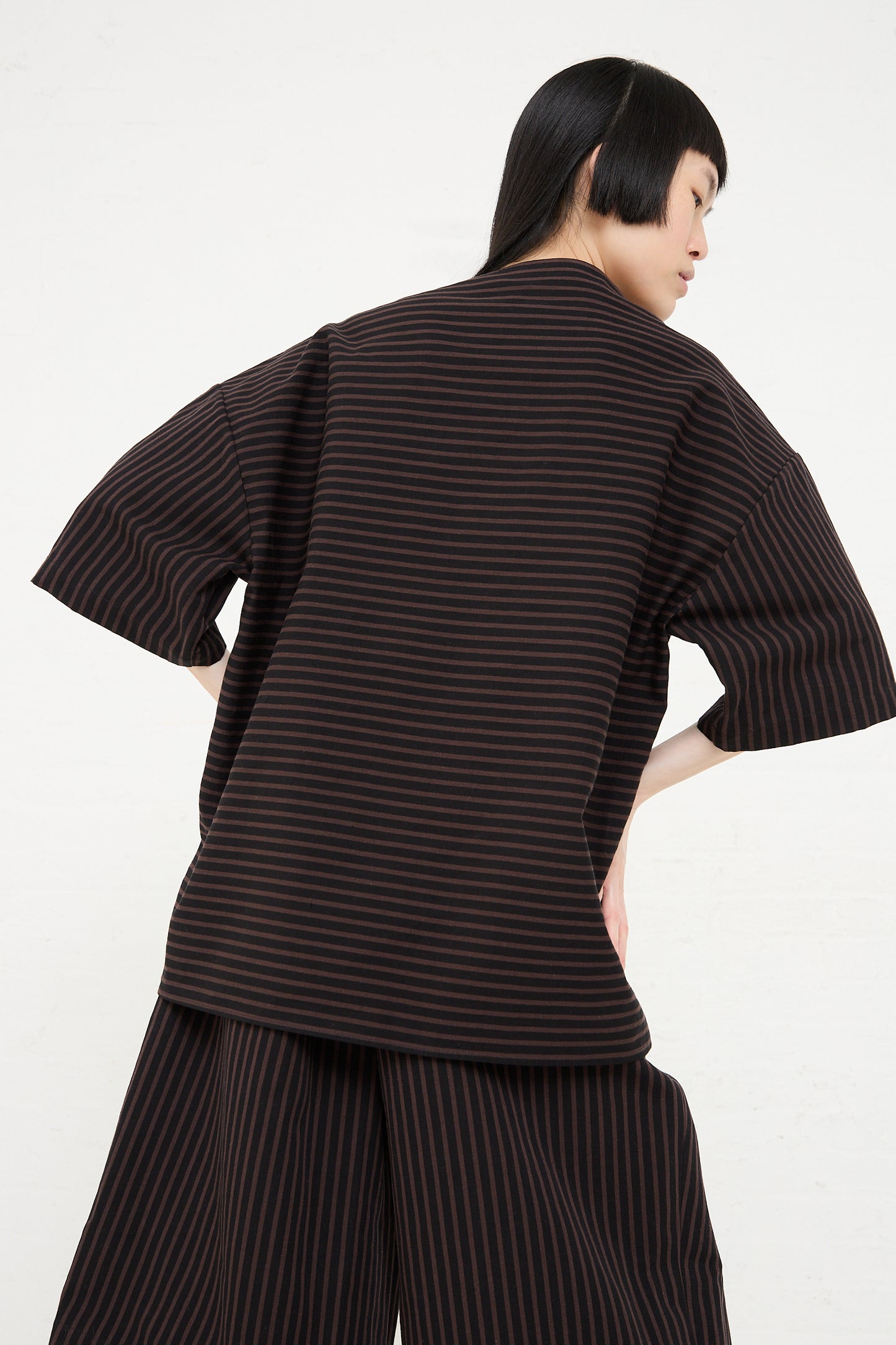Woman from behind wearing a Rachel Comey Ode Top in Black with a boatneck collar and matching trousers.