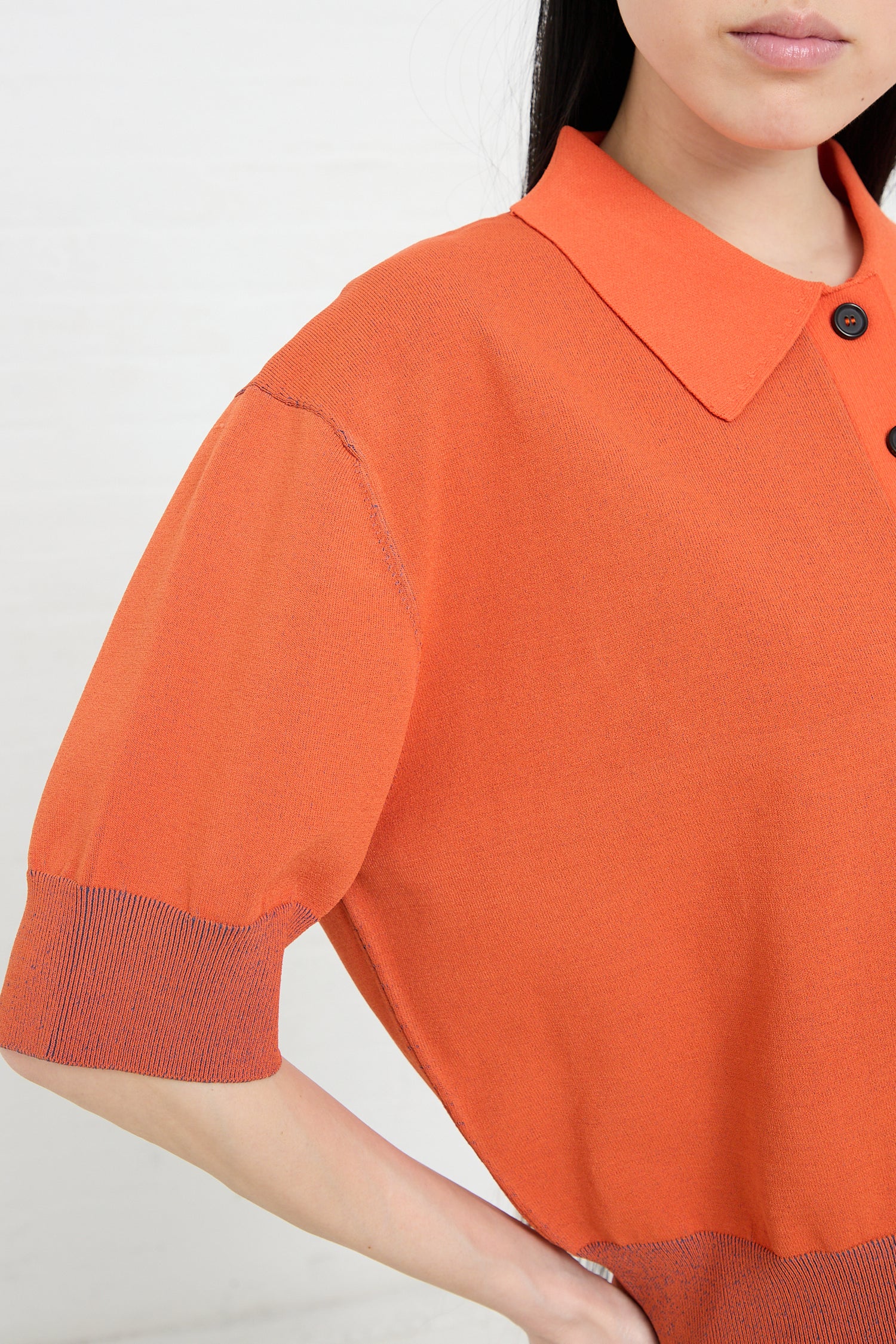 Woman wearing a Rachel Comey Omin Top in Orange, designed in crepe knit and featuring a collar and cuffed sleeves.