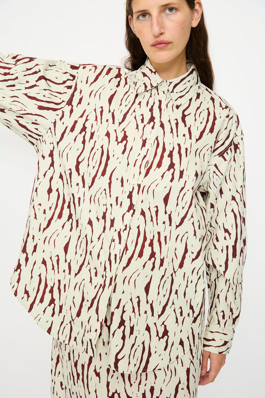Person wearing the Rachel Comey Risa Top in Cream, styled with matching pants in a cream and maroon abstract Tiikeri print, standing against a plain white background.
