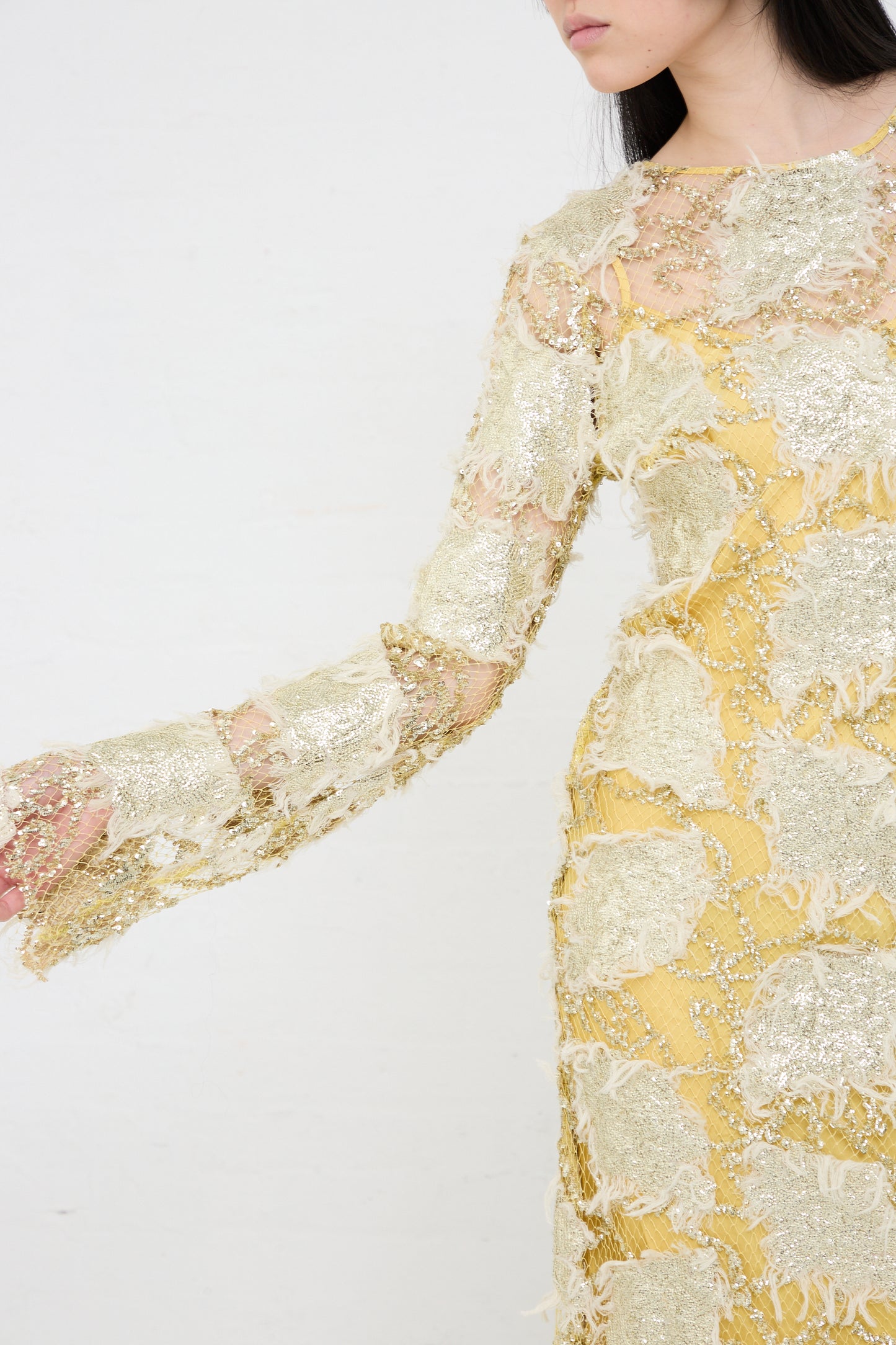 Woman wearing a yellow midi Silla Dress in Gold by Rachel Comey with intricate golden metallic embroidery details.
