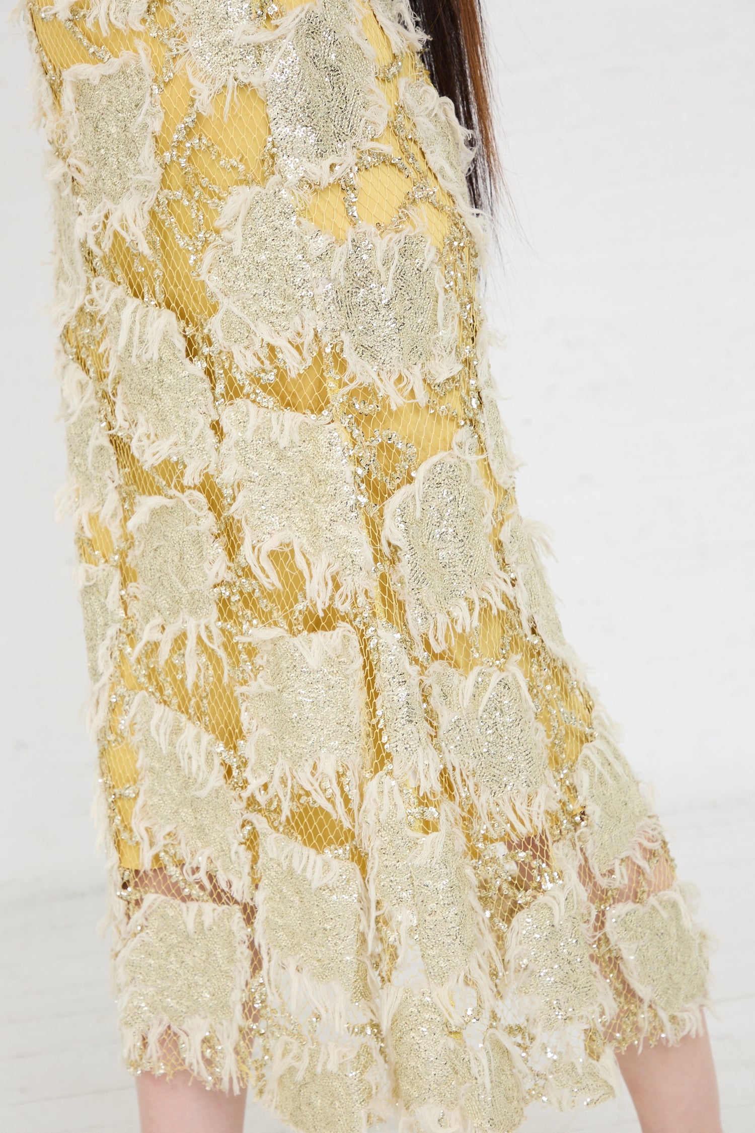 Close-up of a Rachel Comey Silla Dress in Gold with intricate detailing.
