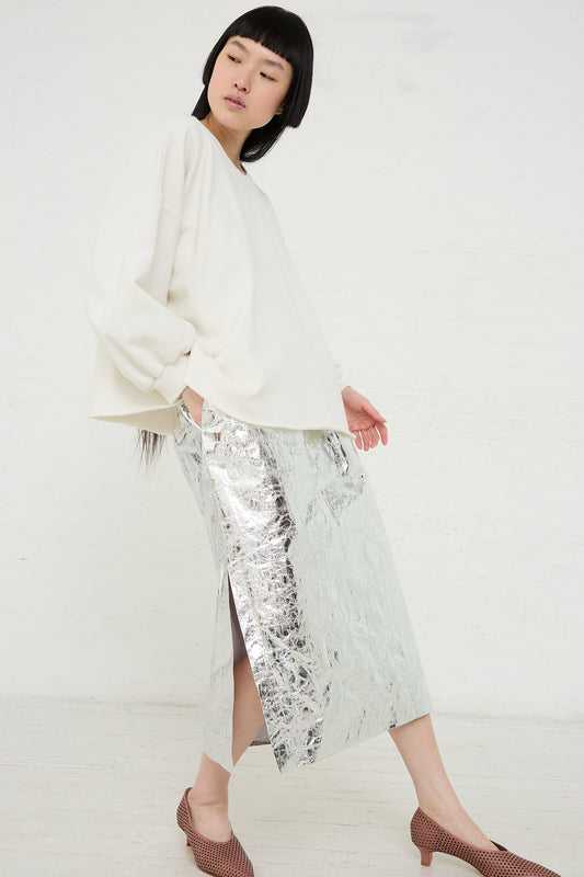 Woman in a white blouse and a Rachel Comey Mott Skirt in Silver posing for a fashion shoot.
