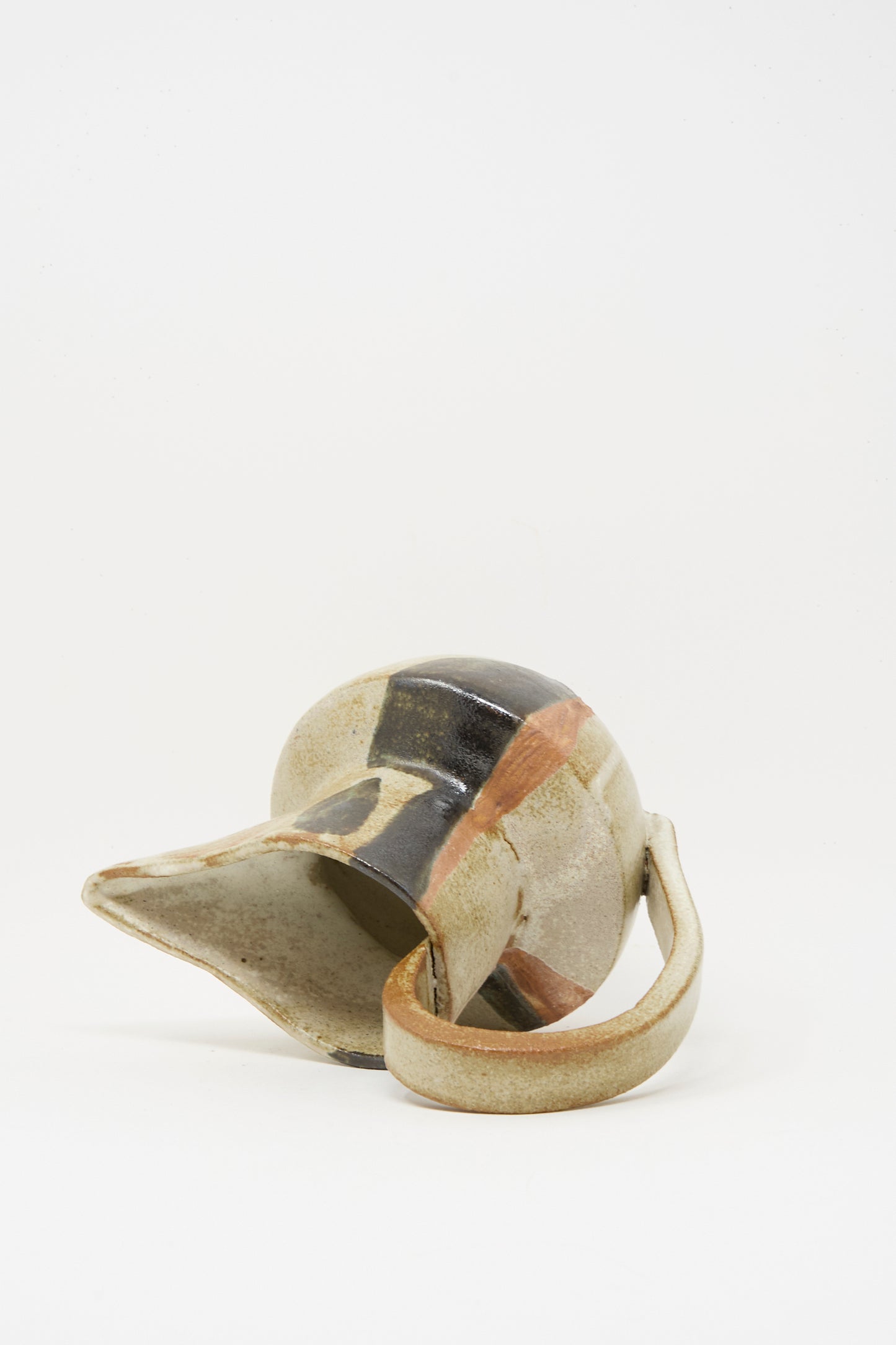 The Drawn Pitcher in Creme by Rachel Craven rests on its side, handle facing forward, against a plain white background.