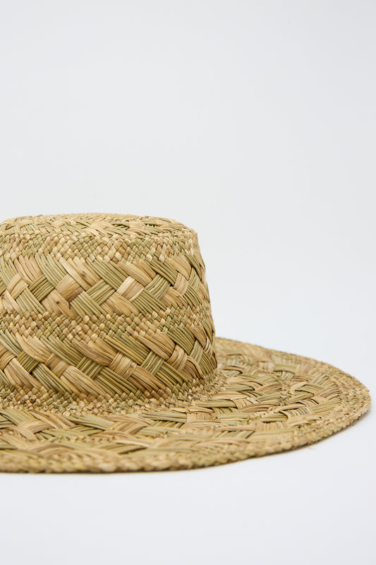A close-up of a Reinhard Plank Treccia Lai Straw Hat in Natural against a plain white background, showing detailed texture.
