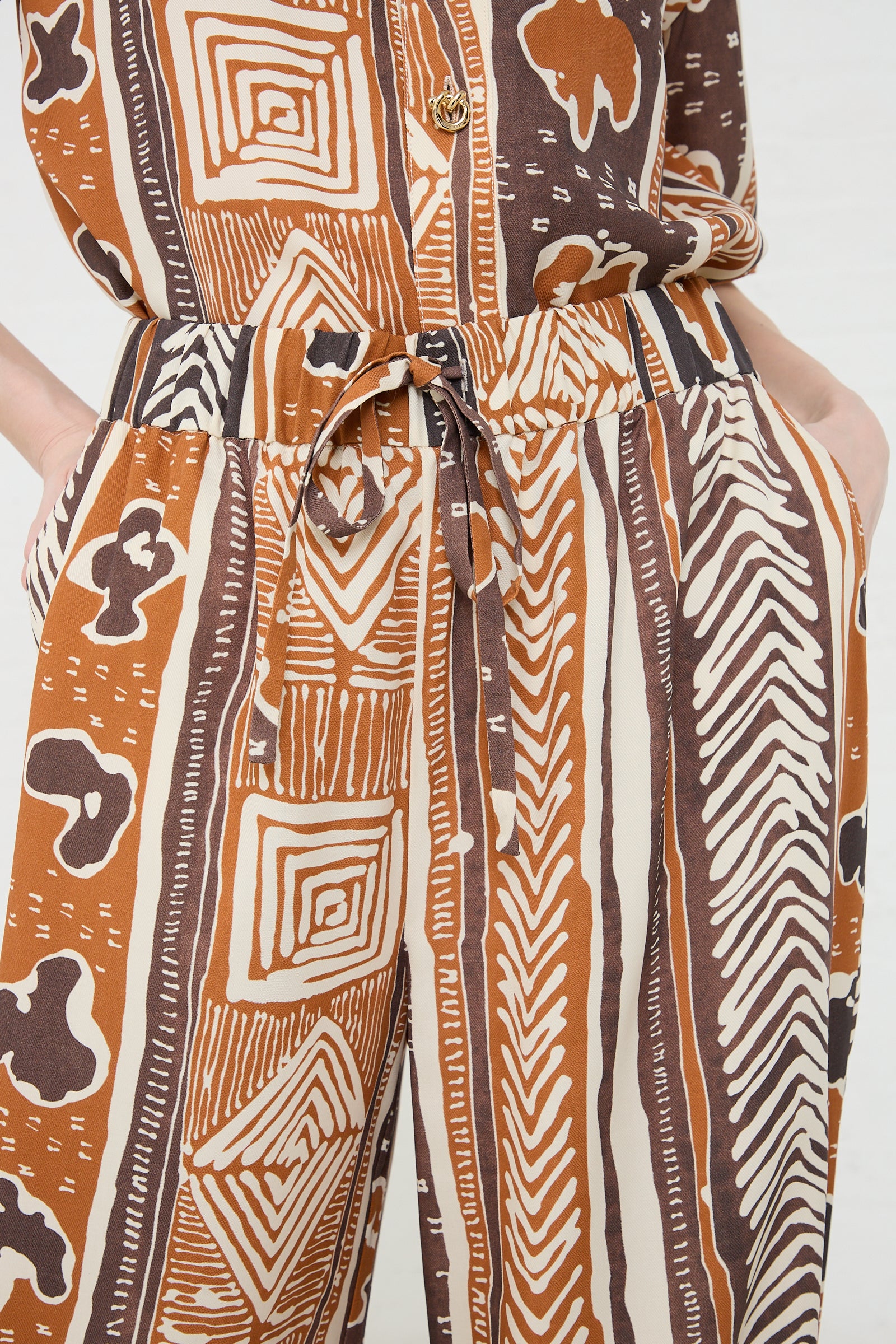 Close-up of a person wearing Rejina Pyo Andi Trouser in Print Brown with geometric designs.