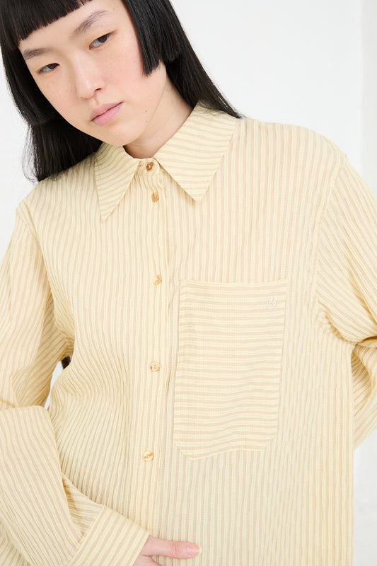 A woman in a Rejina Pyo Organic Cotton Seersucker Caprice Shirt in Stripe Yellow with a focus on the collar and pocket details.