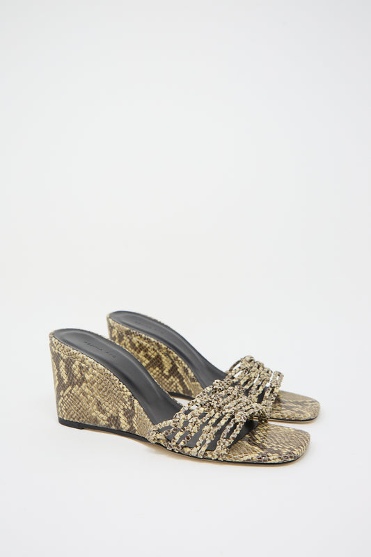 A pair of women's Leather Print Kyle Wedges in Snake Butter by Rejina Pyo with embellishments and a woven front strap on a white background.
