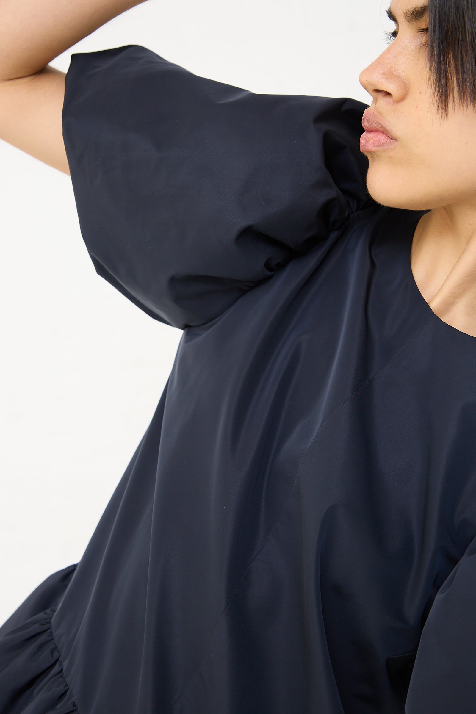 A woman wearing a Silk Alara Blouse in Taffeta Navy by Rejina Pyo.