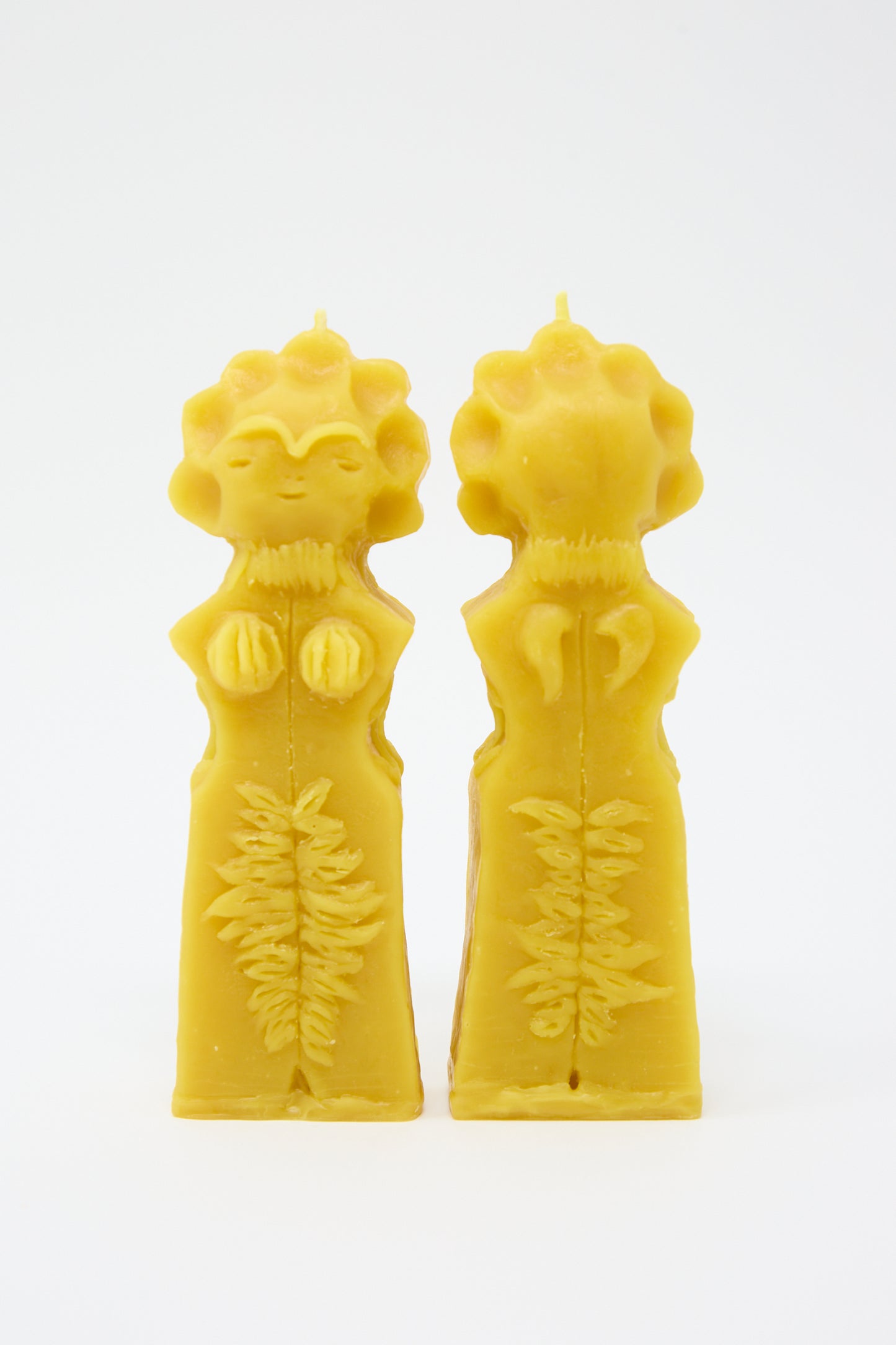 Two Moon Goddess Candles by Rinn to Hitsuji, shaped like figures and featuring detailed botanical patterns, stand against a white background.