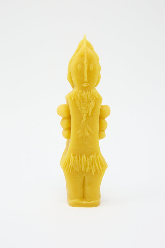 A yellow Plant Goddess Candle, hand formed in the shape of a humanoid figure with detailed features and decorative elements, set against a white background by Rinn to Hitsuji.