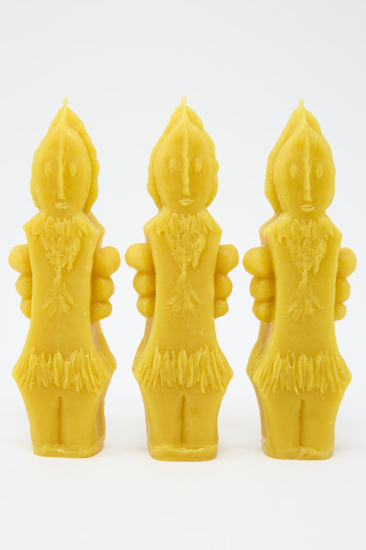 Three yellow Rinn to Hitsuji Plant Goddess Candles shaped like humanoid figures with detailed carving, isolated on a white background.