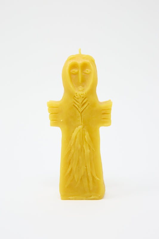Yellow natural wax Sky Goddess Candle shaped like a figure with spread arms and facial details, on a white background, by Rinn to Hitsuji.