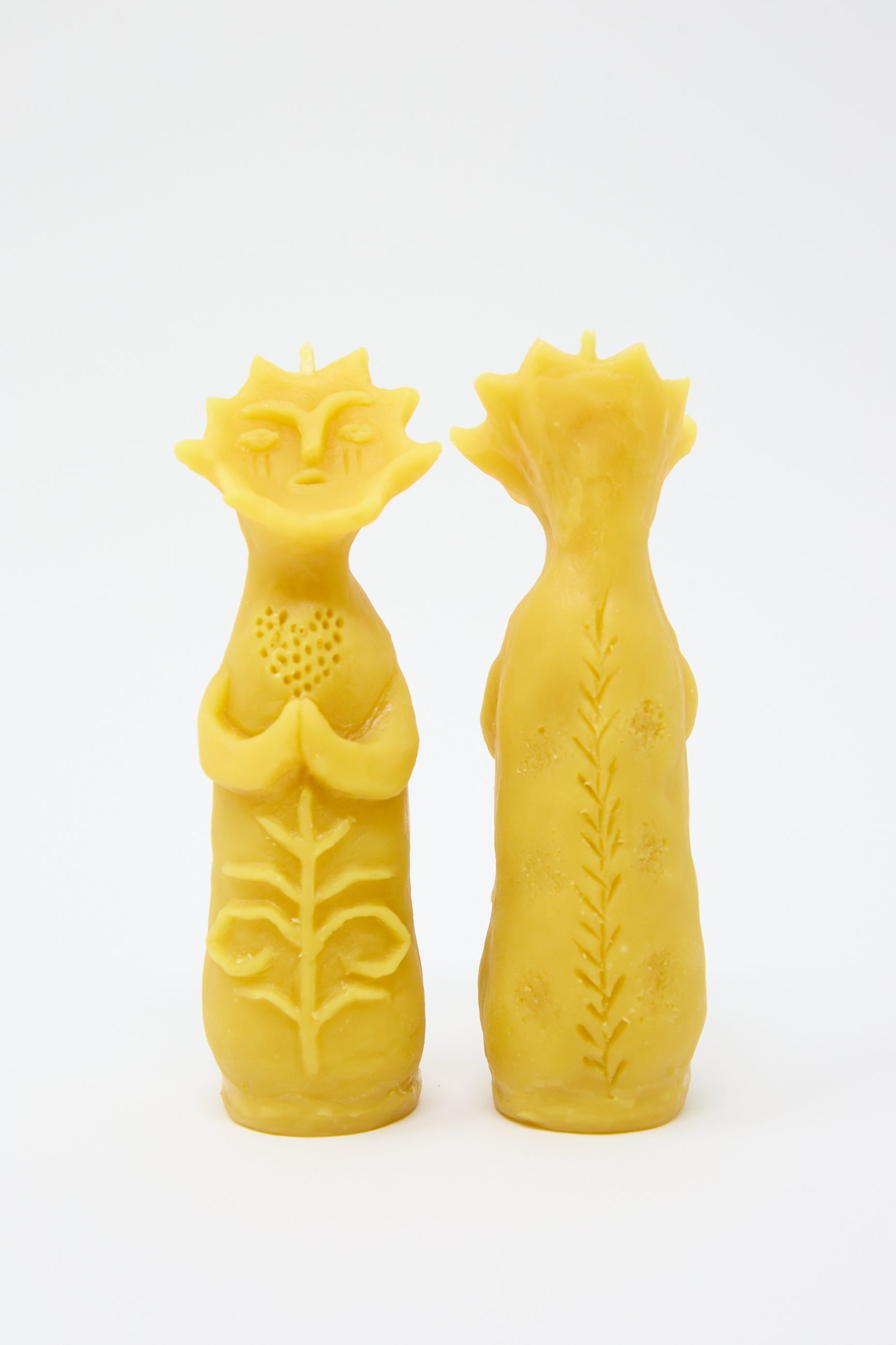 Two Rinn to Hitsuji Sun Goddess Candles shaped like anthropomorphic plants, with one resembling a sunflower and the other a stalk of wheat, against a white background.