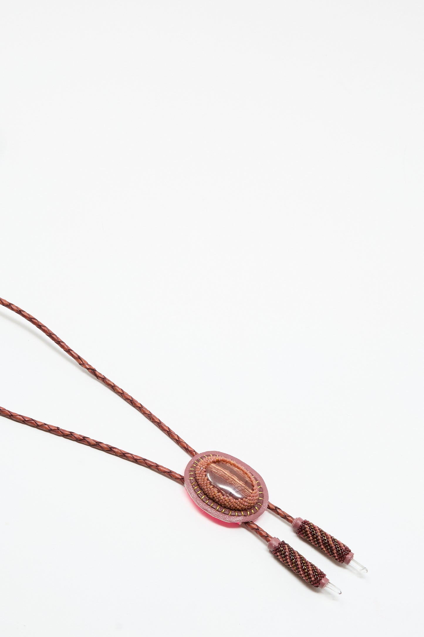 The Robin Mollicone Bolo Necklace in Snakeskin Jasper and Quartz features a brown braided cord, an oval jasper centerpiece, and decorative tips. Handmade in NYC, it's displayed on a plain white background.