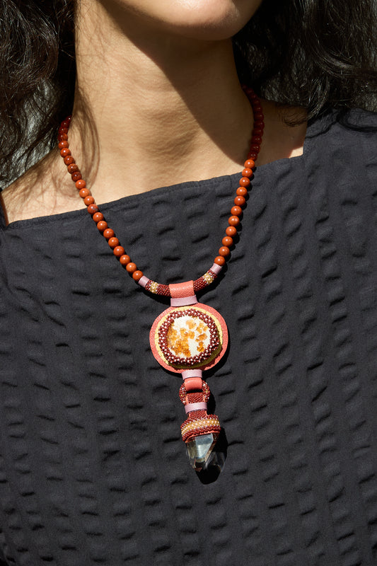 A person wearing a Double Stone Necklace with Red Jasper Beads adorned with fire opal stones by Robin Mollicone.