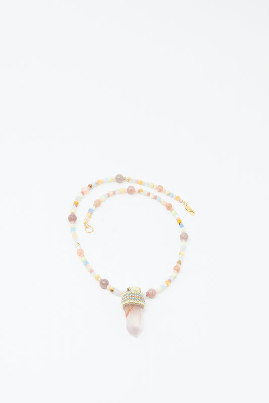 The Peace of Mind Necklace by Robin Mollicone is a handmade NYC piece with multicolored vintage glass beads, gold clasps, and a pointed pink crystal pendant wrapped in gold wire.