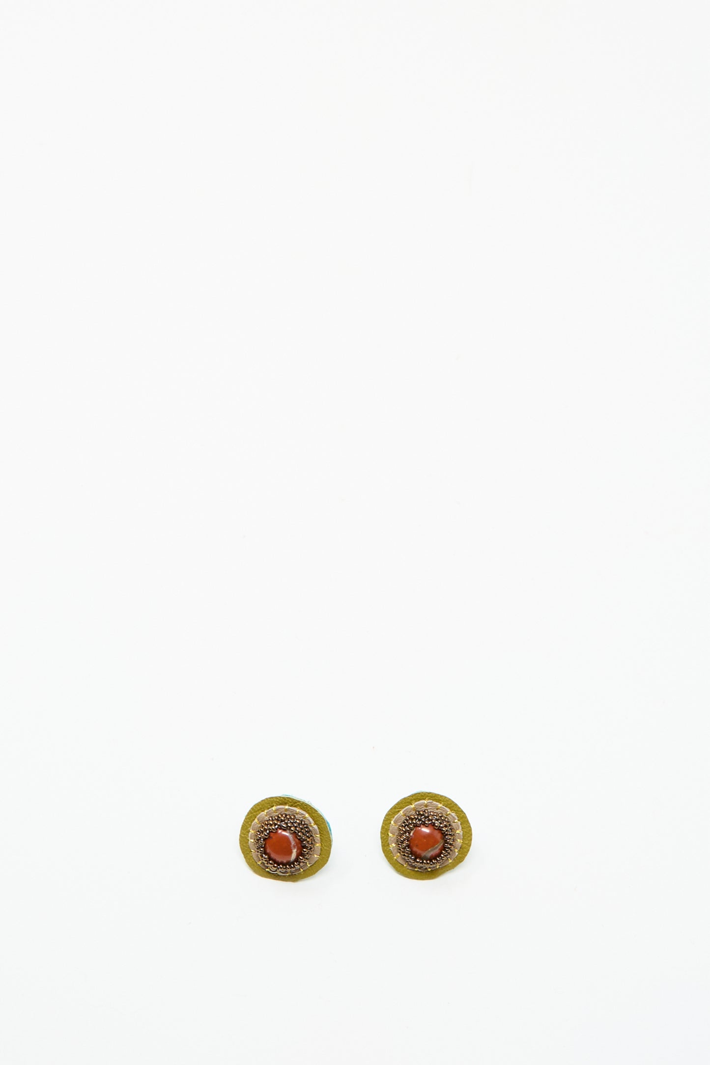 The Stud Earrings in Red Jasper by Robin Mollicone are round, handmade earrings with a gold outer ring and Red Jasper center, shown on a plain white background.