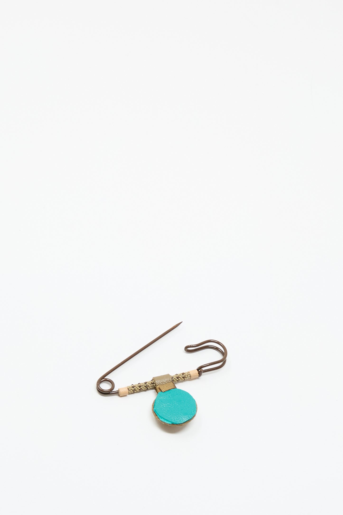 The Gem Drop Safety Pin in Brown with Picture Jasper by Robin Mollicone features a turquoise circular charm and decorative beading, displayed on a plain white background.