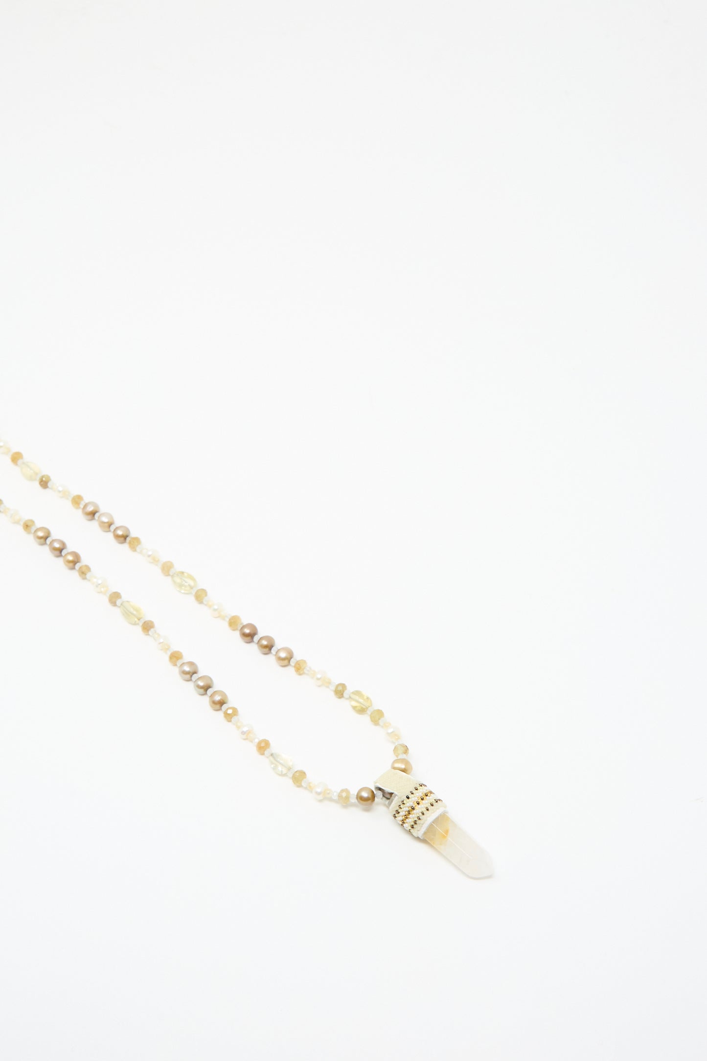 The Peace of Mind Necklace by Robin Mollicone features mother of pearl beads and a quartz crystal pendant with gold accents, displayed on a white background.
