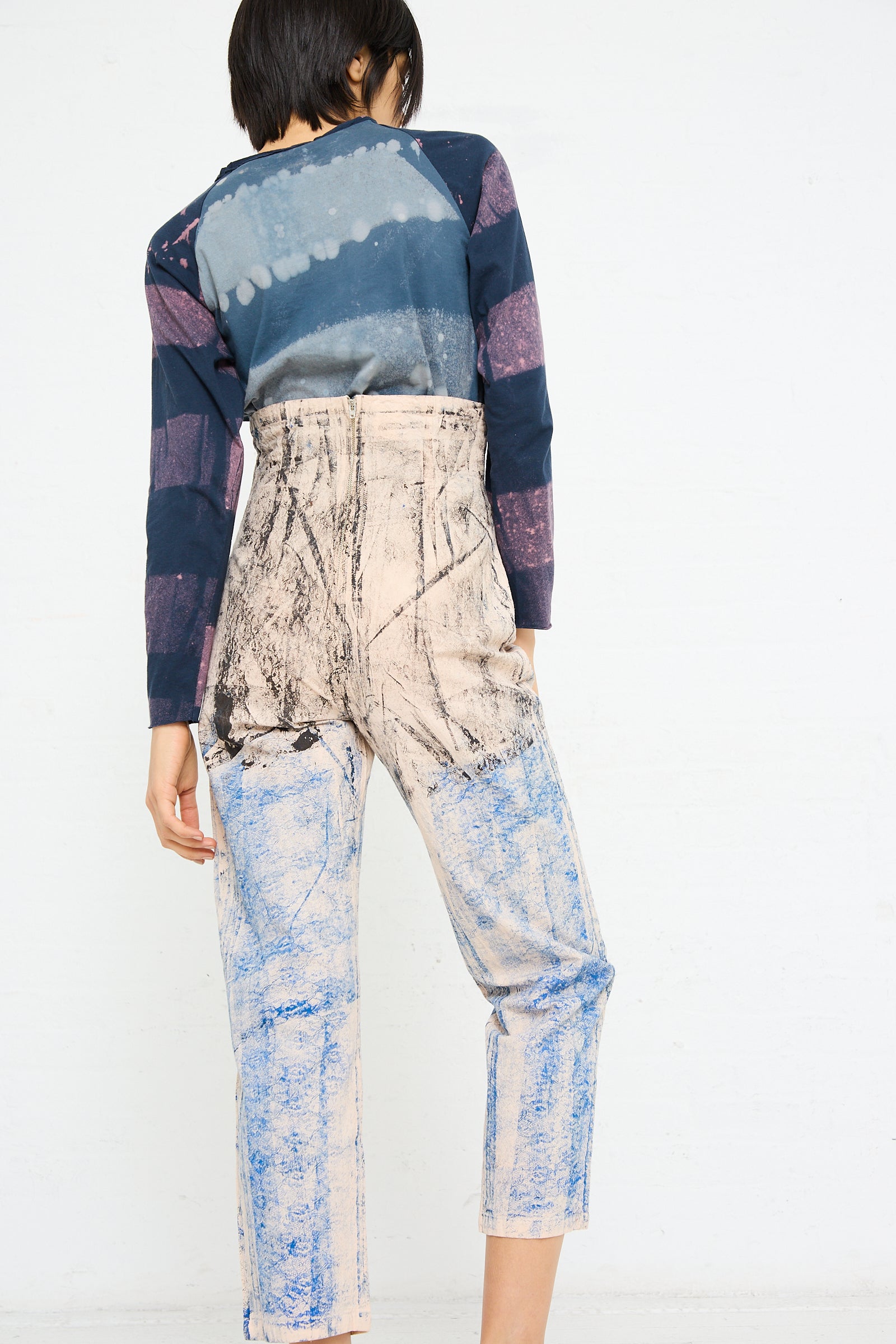 Woman from behind wearing a Lace Print Cotton Legend Trouser in Ink by SC103 and distressed, cropped pant.
