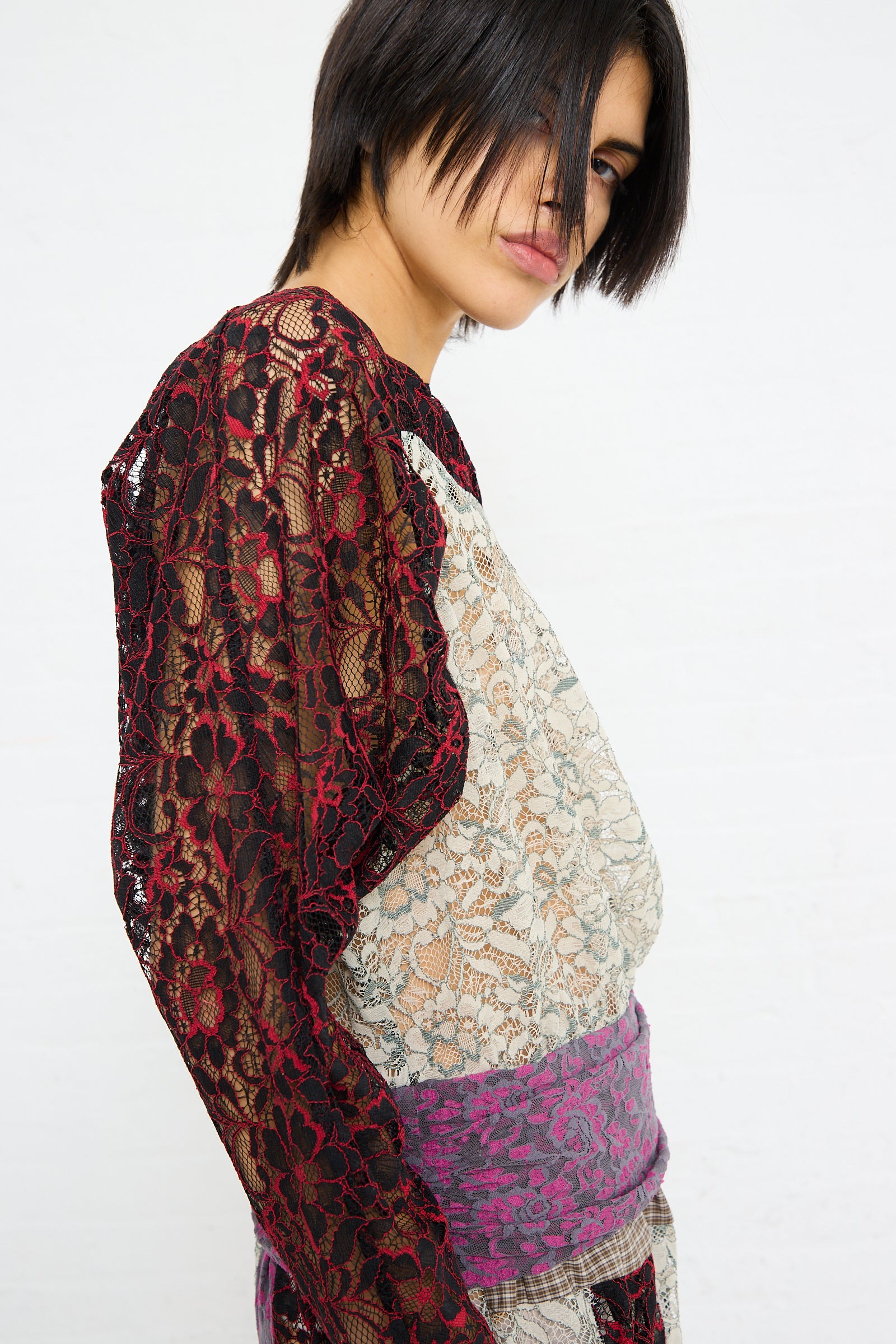 Woman in SC103 Lace Ritual Top in Thrash with patterned skirt looking over her shoulder.