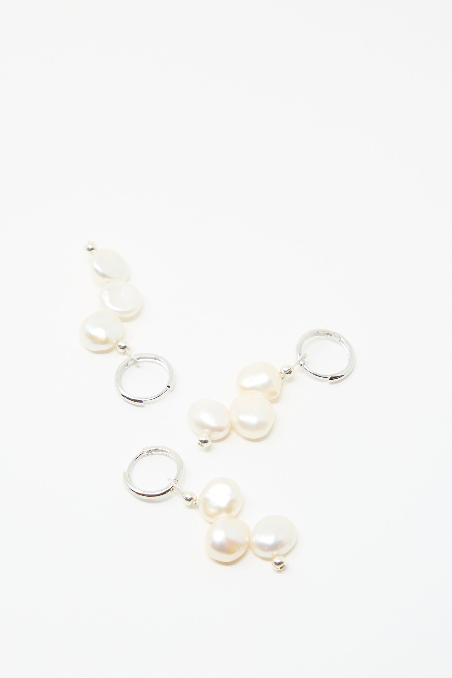 Three pairs of Santangelo's Baba Earring in Triple Baby, each sterling silver hoop adorned with two freshwater keshi pearls, displayed on a plain white background.
