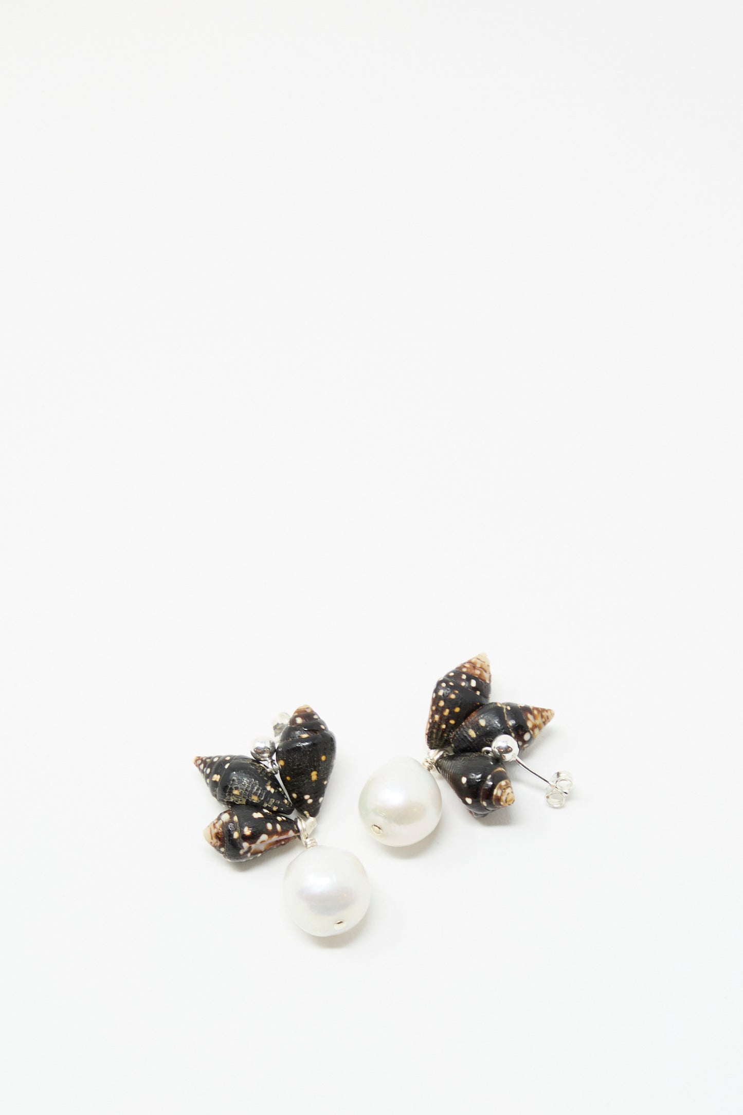 The Santangelo Bepe Earrings in Pyrene are handmade drop earrings with black, butterfly-shaped sterling silver tops, small white spots, and large round keshi pearl drops, shown against a white background.