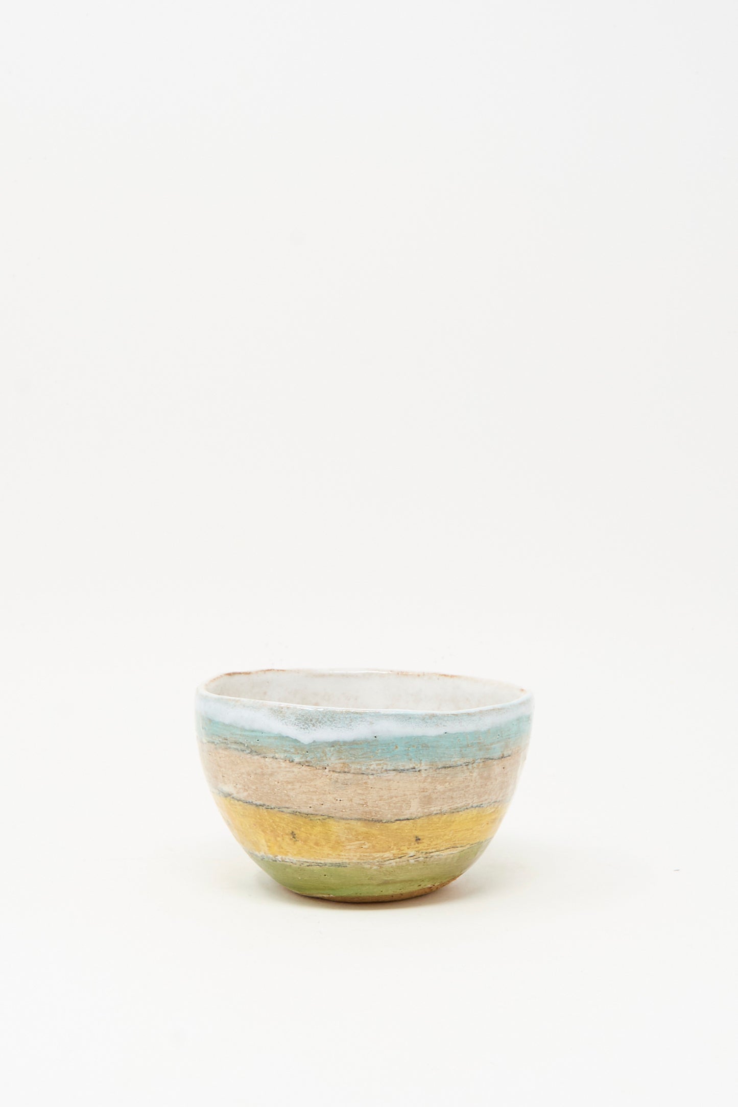 The Small Bowl in Stripe II by Shino Takeda is a handmade ceramic bowl from New York, featuring hand-painted blue, tan, and green stripes on a white background.